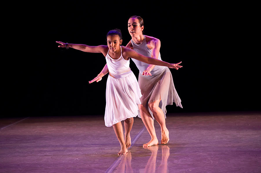 Dancer Kelly Vaghenas and student-dancer Emily perform and move as though on a balance beam.