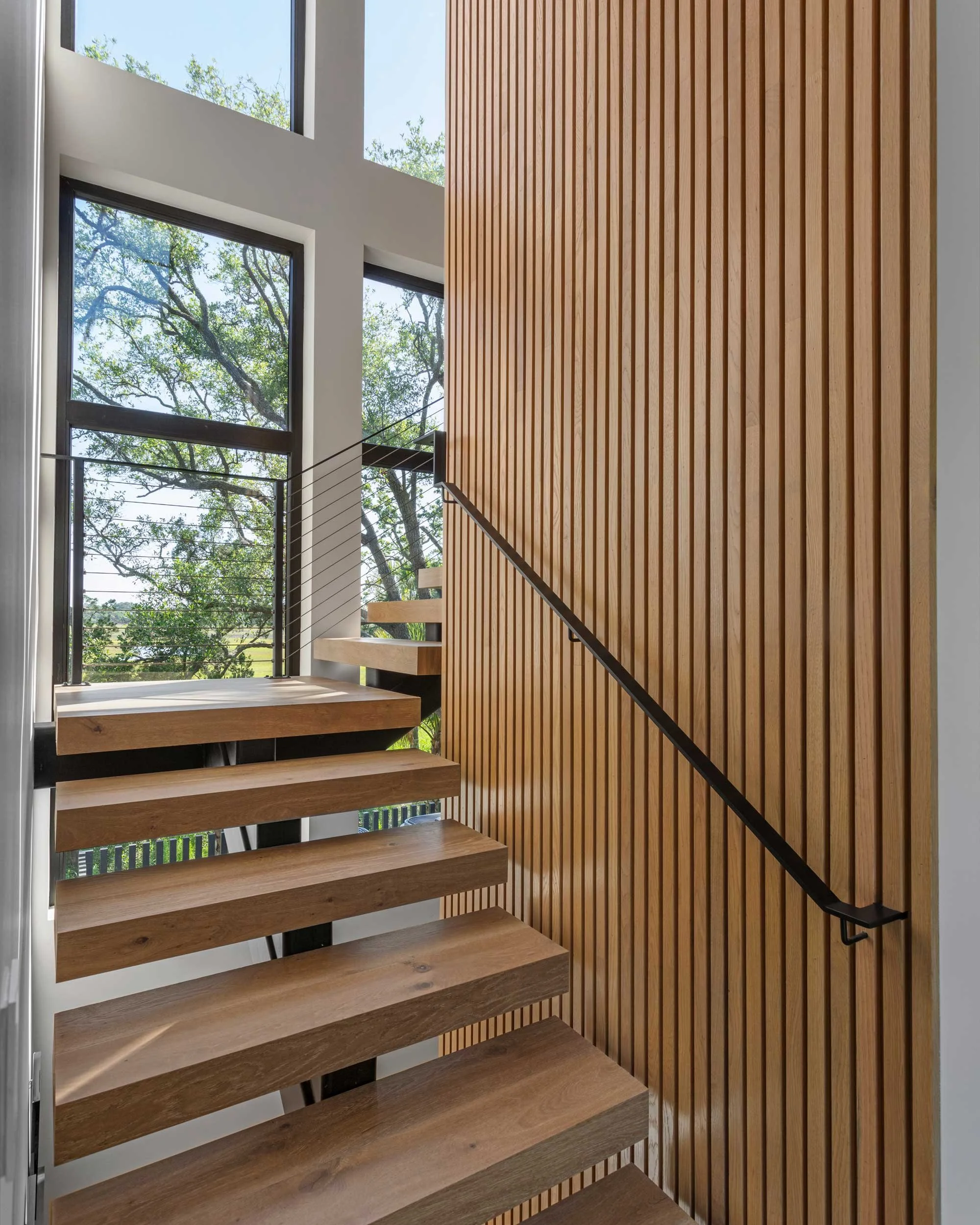 custom-designed-floating-staircase-bordered-by-vertical-slat-wall.jpg
