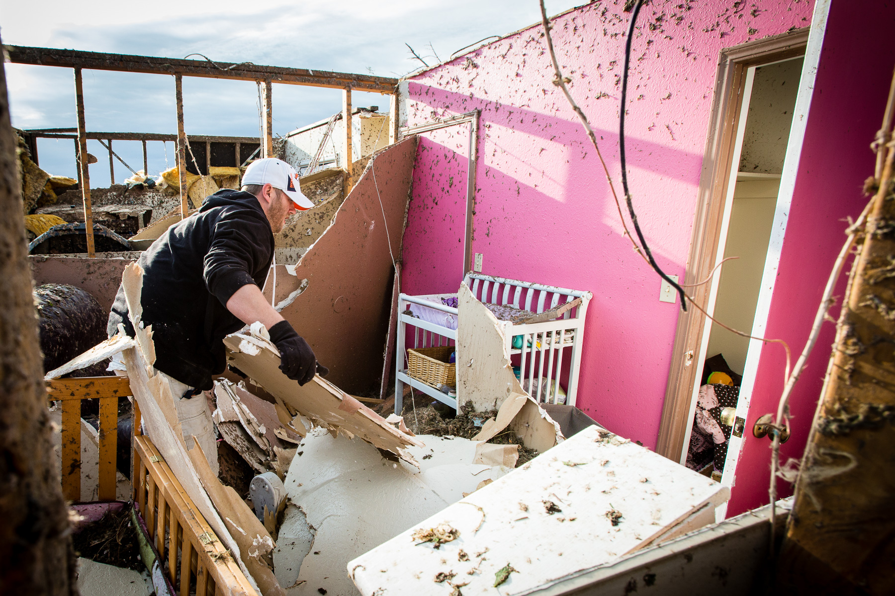 A man clears debris from his daughter's bedroom following a tornado in Moore, Oklahoma.