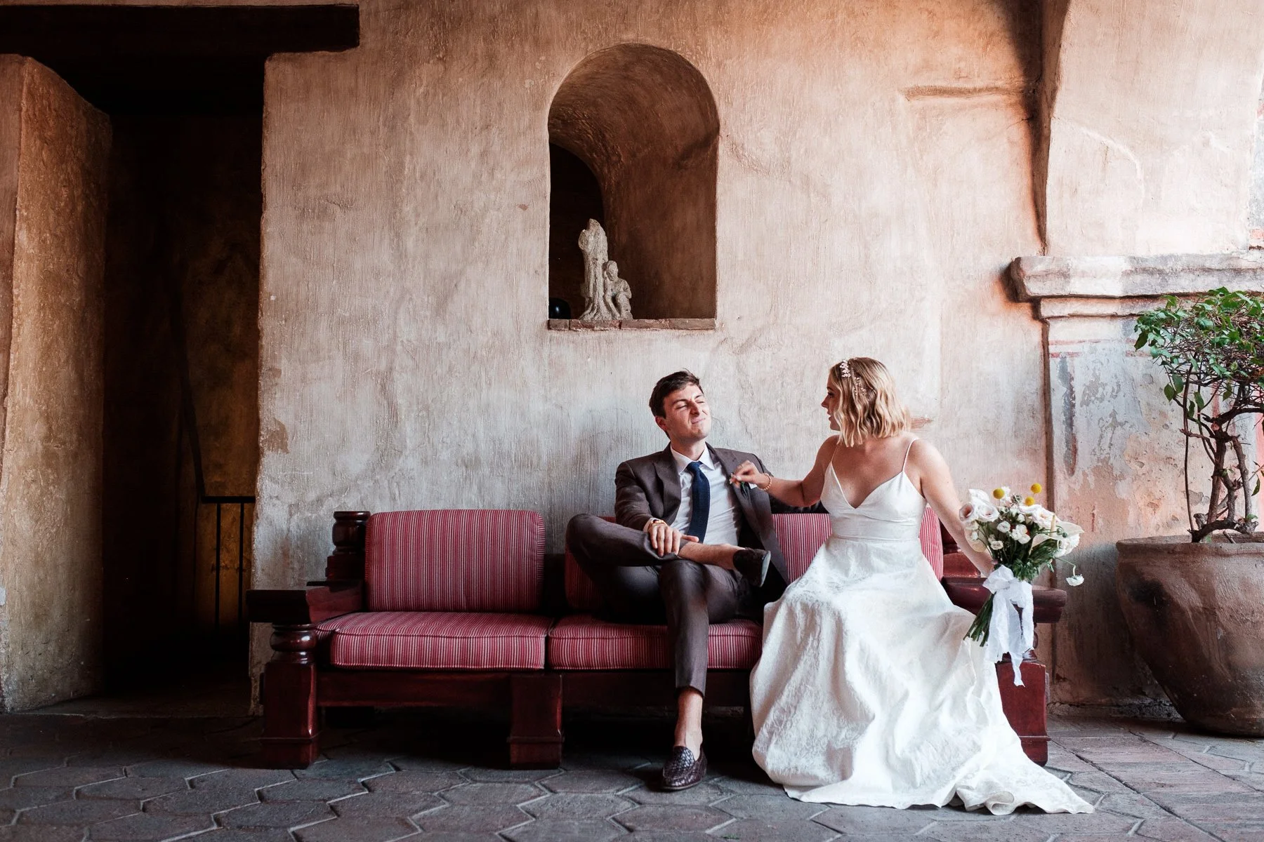 A quiet, unscripted moment of the couple resting on a sofa before their Oaxaca wedding ceremony.
