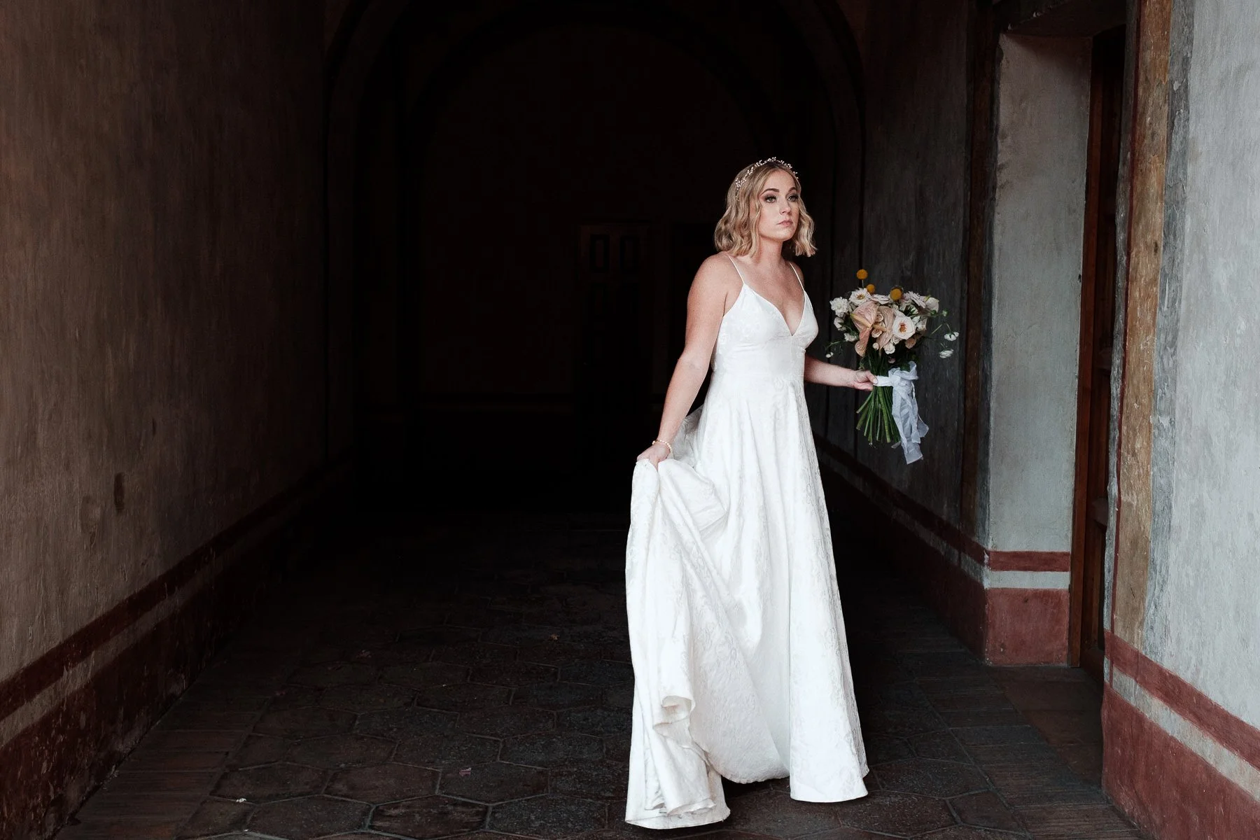 The bride walking through the historic corridors of Quinta Real toward her wedding ceremony.