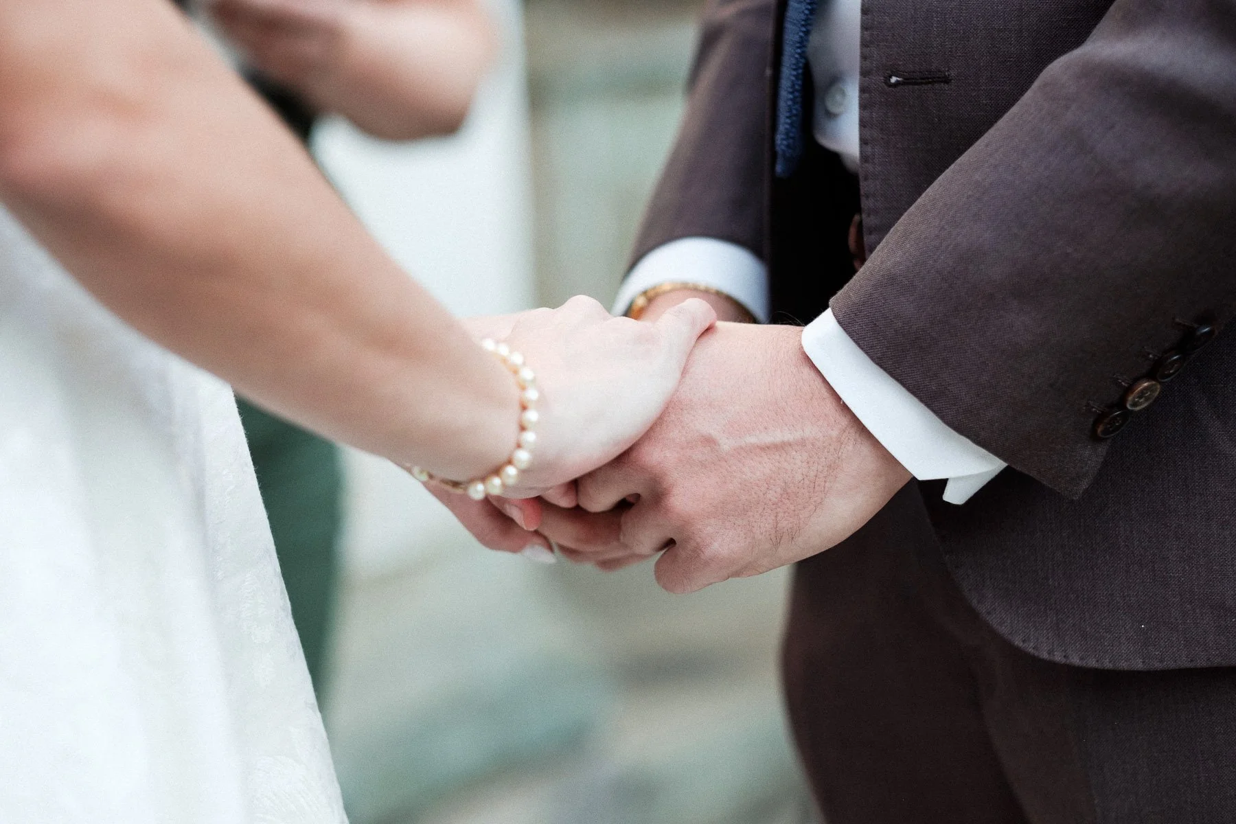Intimate detail of the couple holding hands during their vows in Oaxaca City.