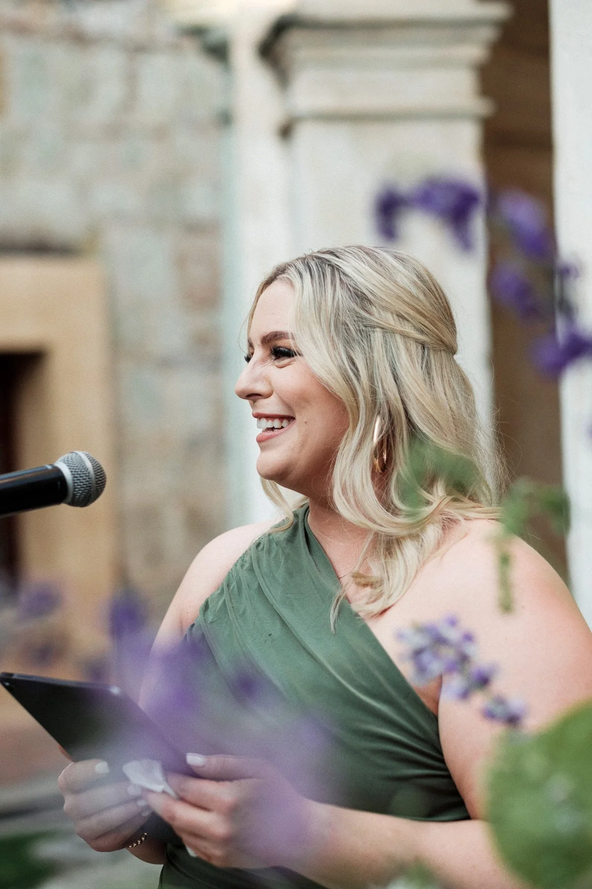 The wedding officiant framed by floral arrangements during the ceremony at Quinta Real.