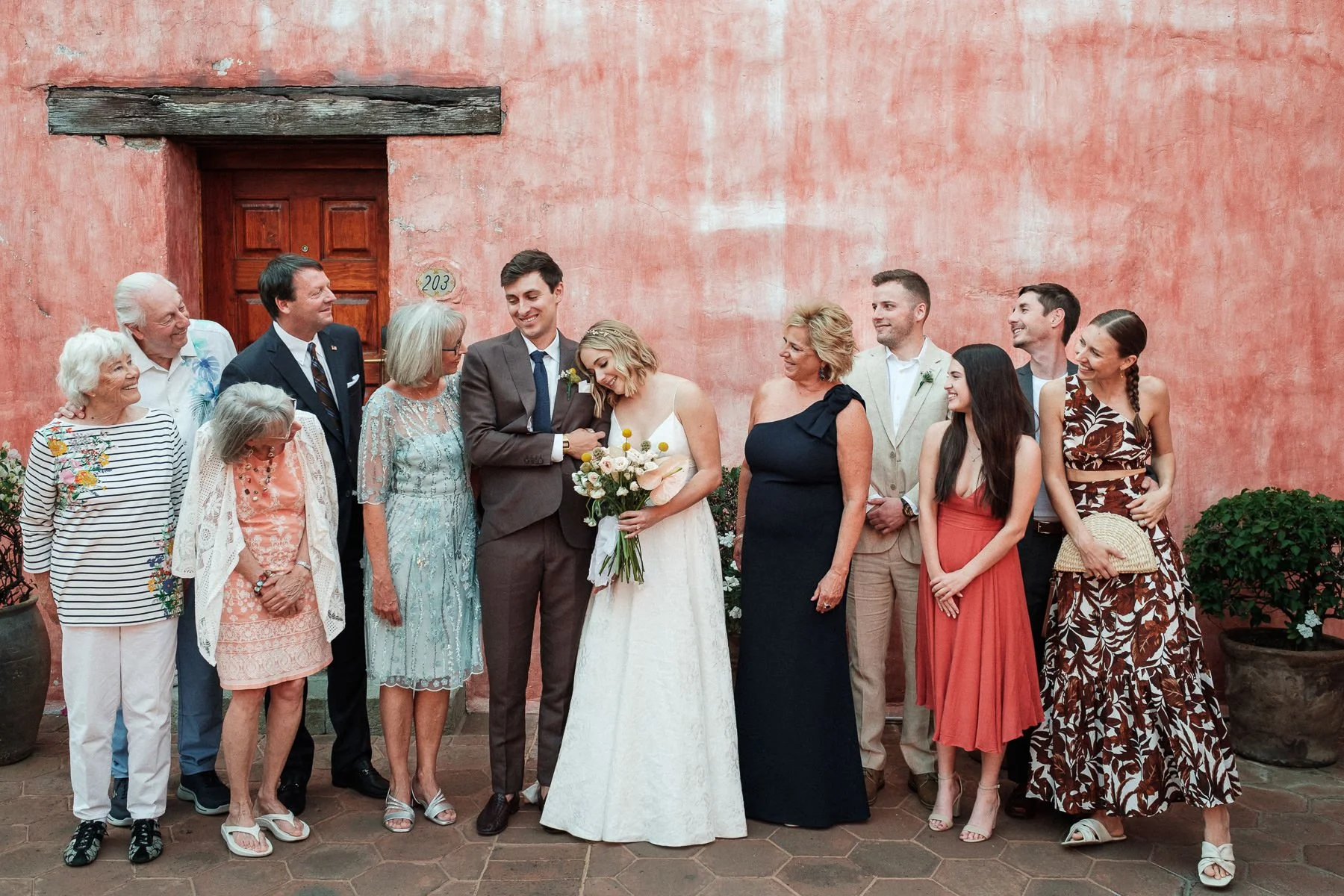 Family group portraits against the iconic architectural pink walls of Quinta Real Oaxaca.