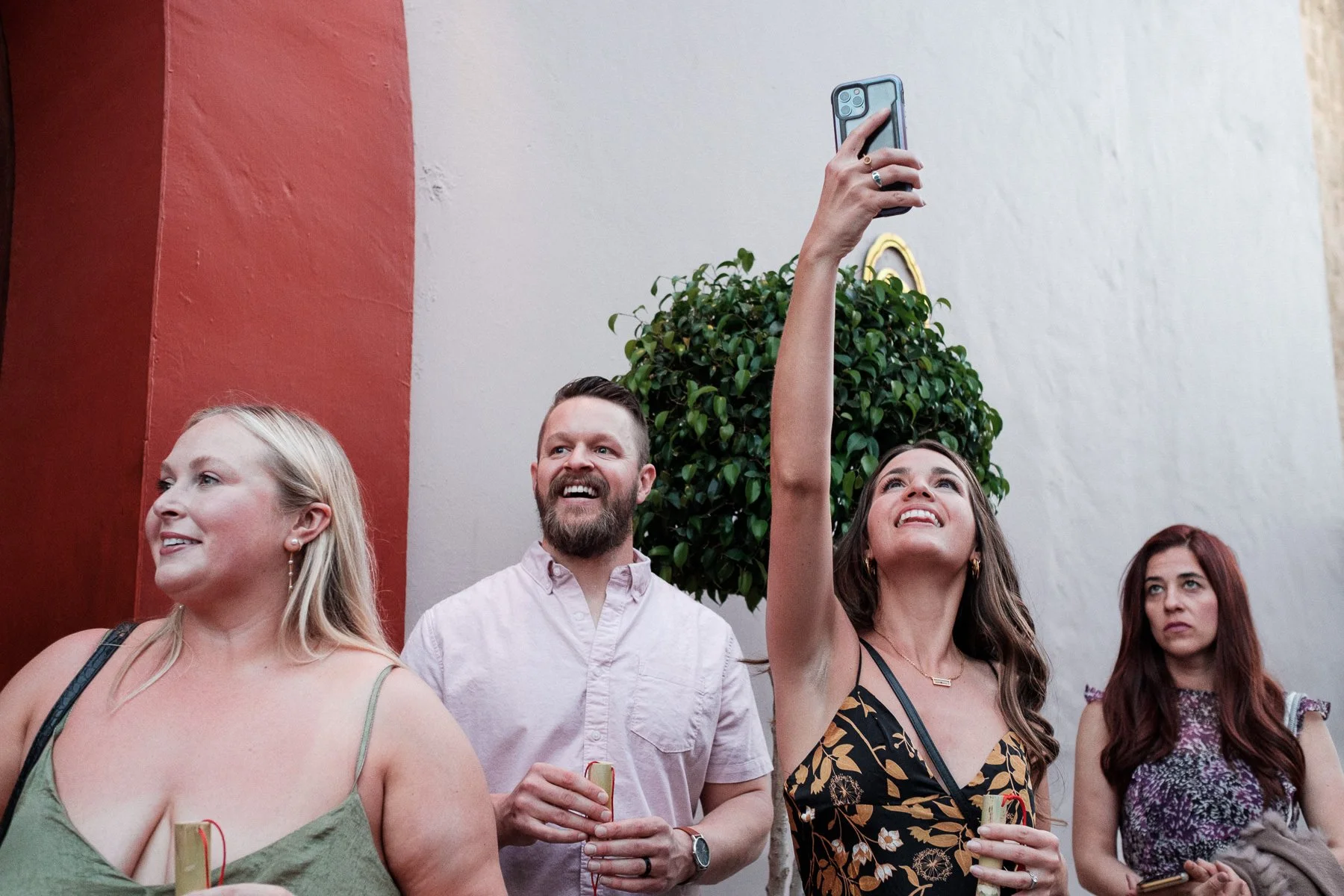 Wedding guests capturing the vibrant energy of the Calenda in the streets of Oaxaca.
