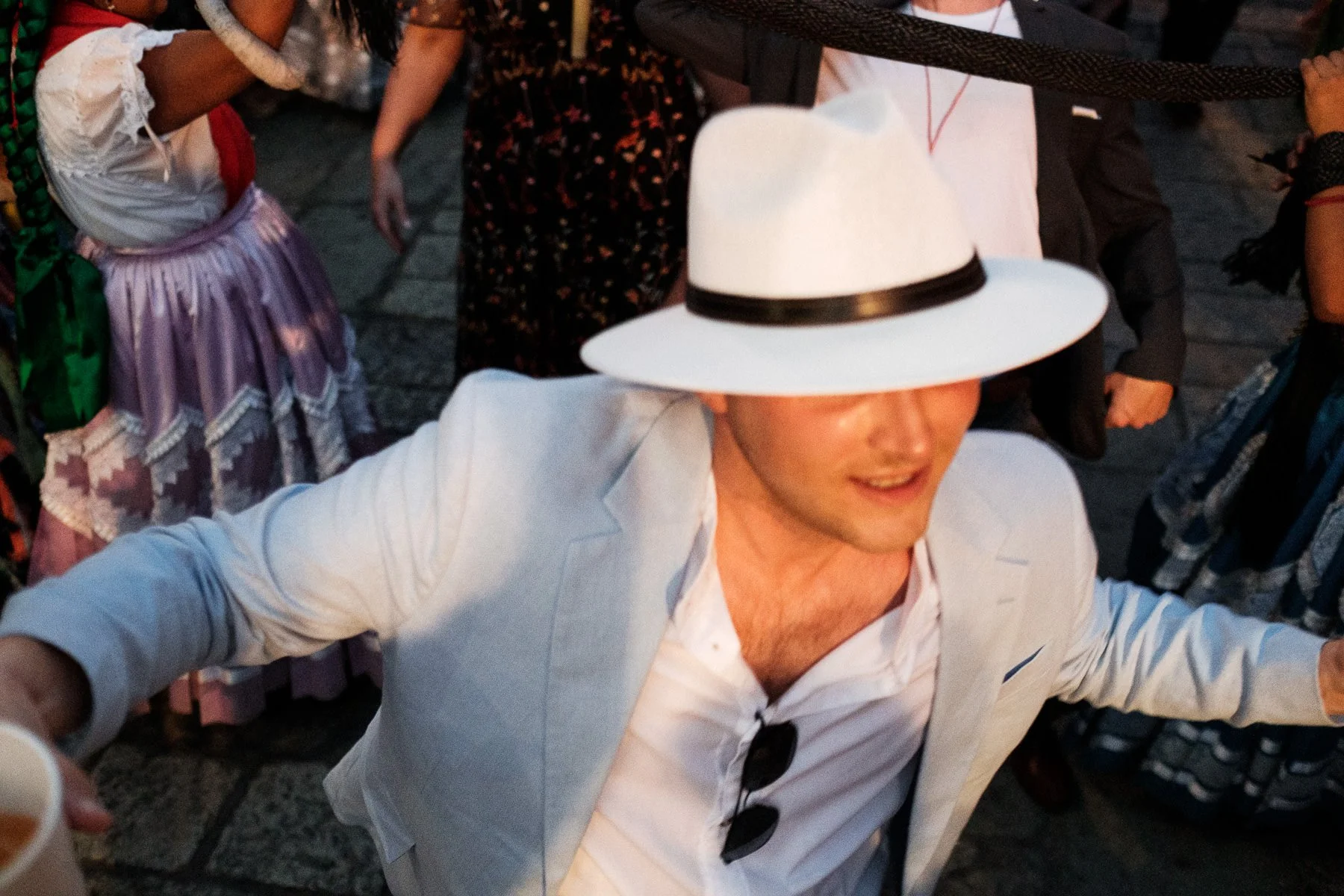A joyful guest joining the traditional dance during a wedding parade in Mexico.