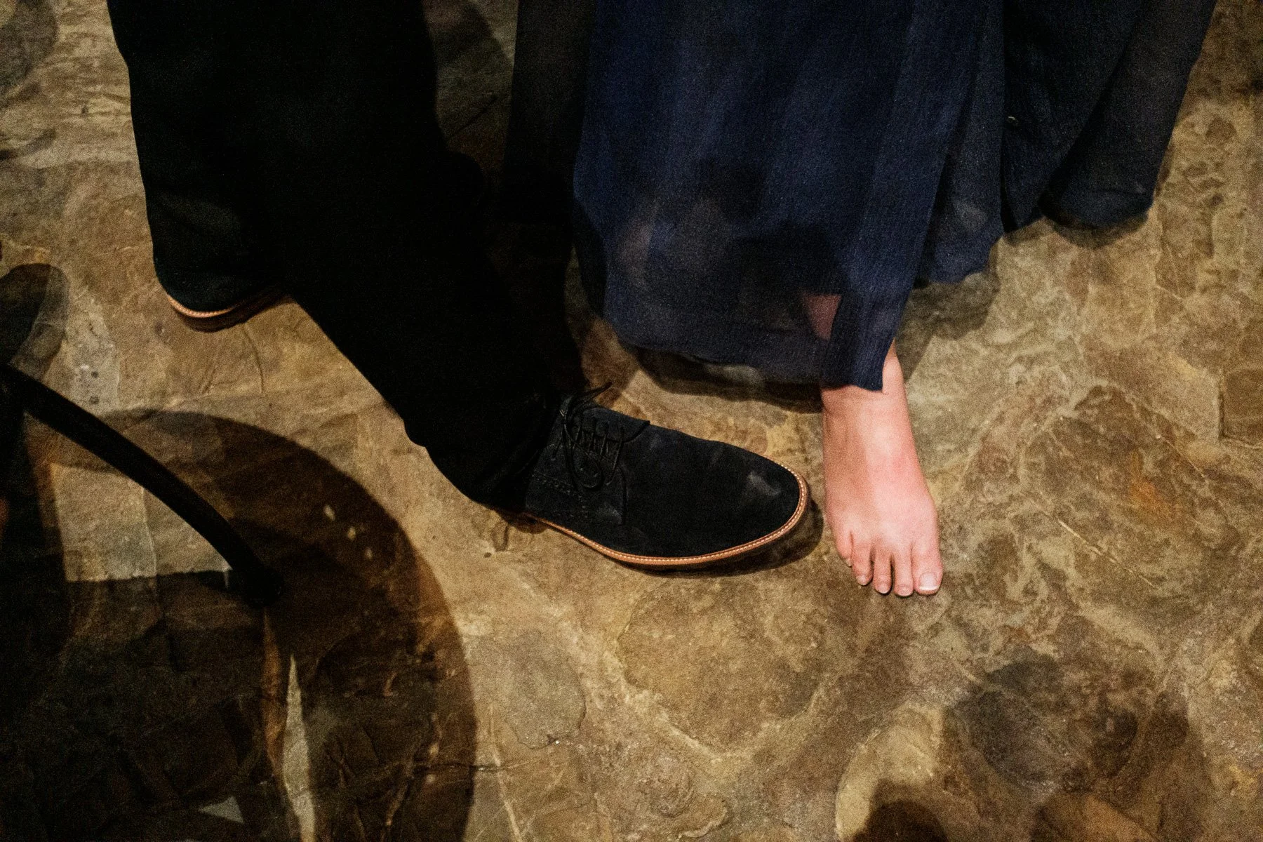A documentary detail of the dance floor: bare feet and wedding shoes in Oaxaca.