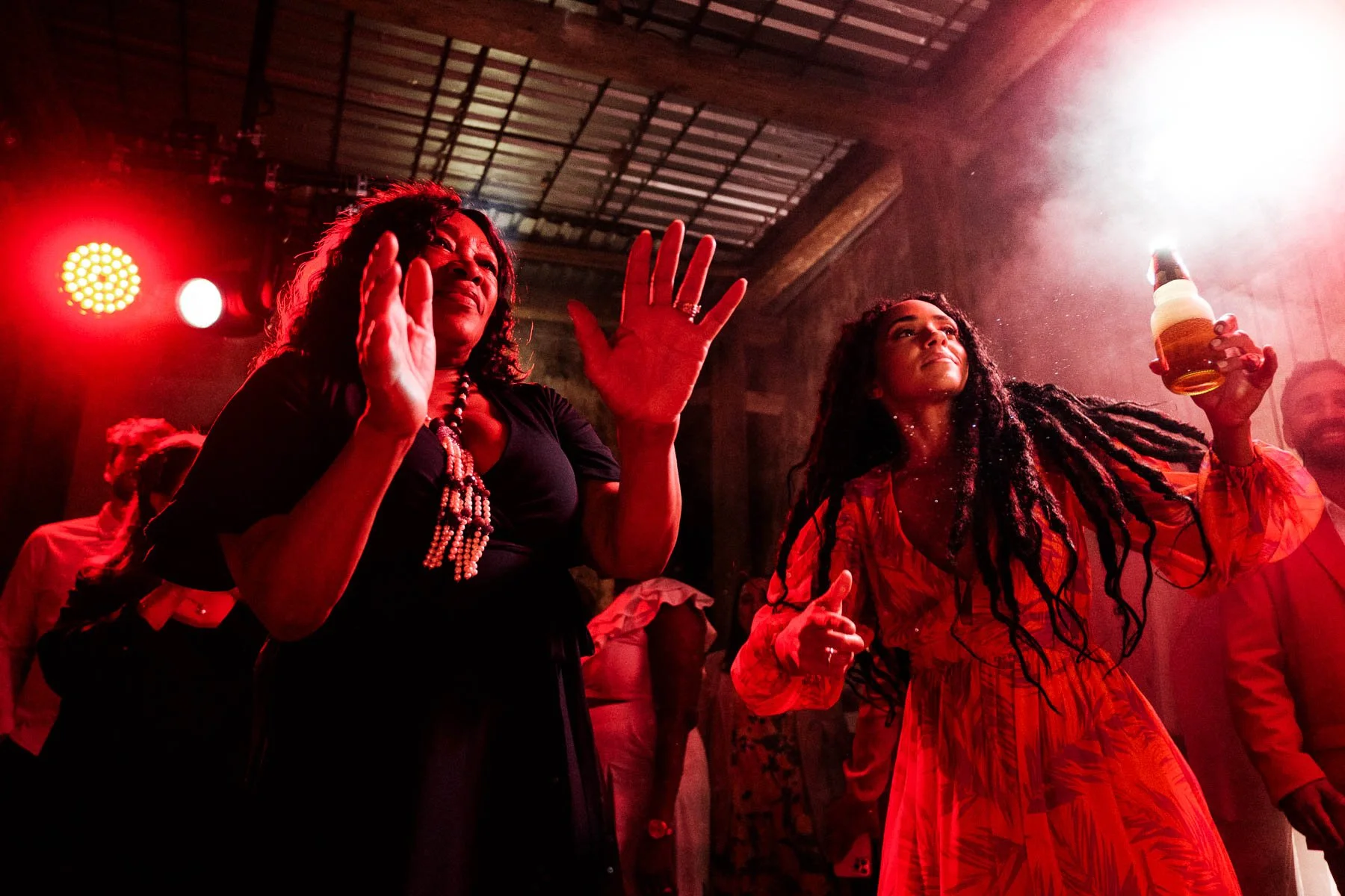 Energetic wedding reception party and dancing at Proyecto Murguia with dramatic red lighting and a lively atmosphere for guests.