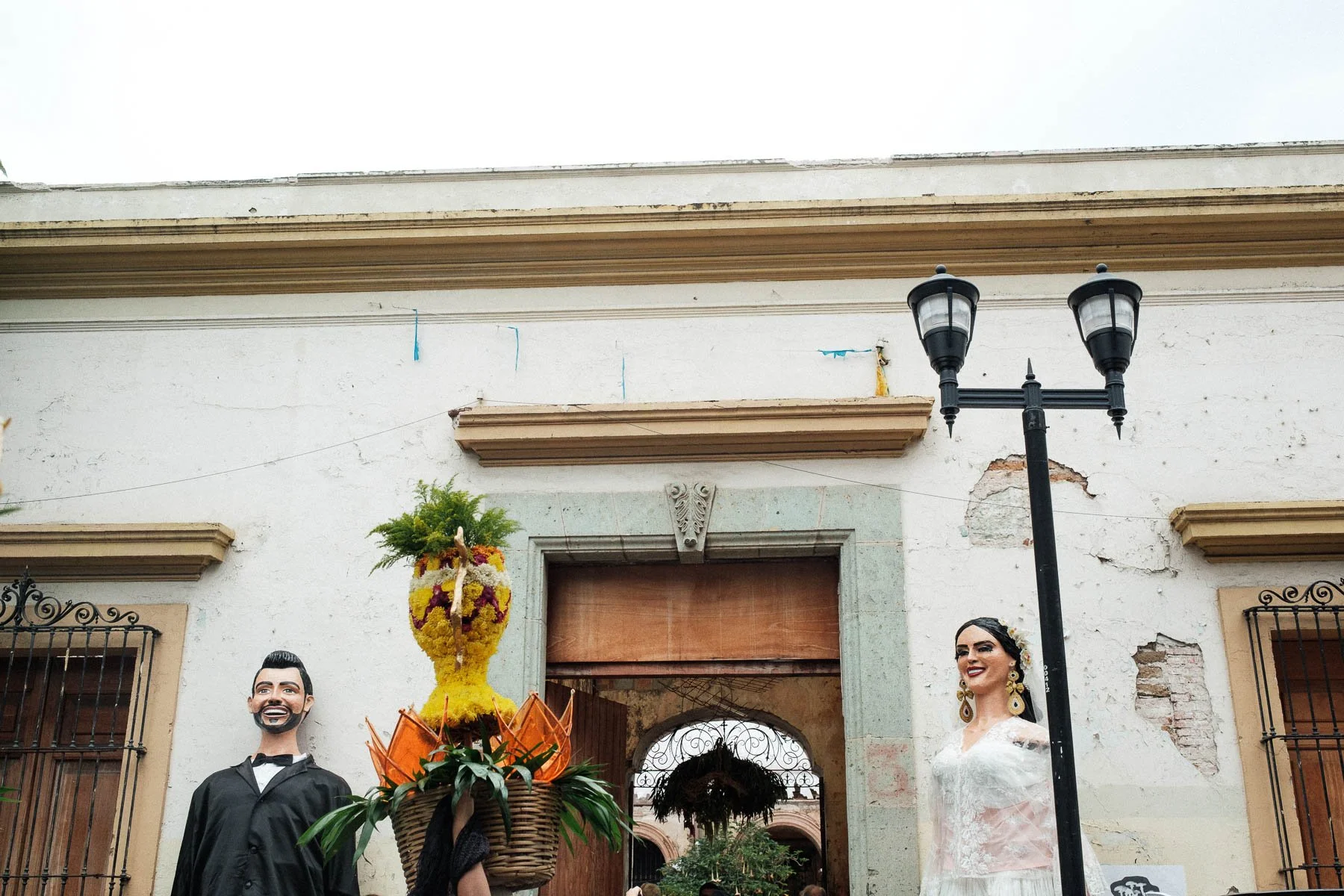 Guests arrive during the finale of a traditional Oaxacan Calenda wedding parade at the historic stone facade of Proyecto Murguia ruins.