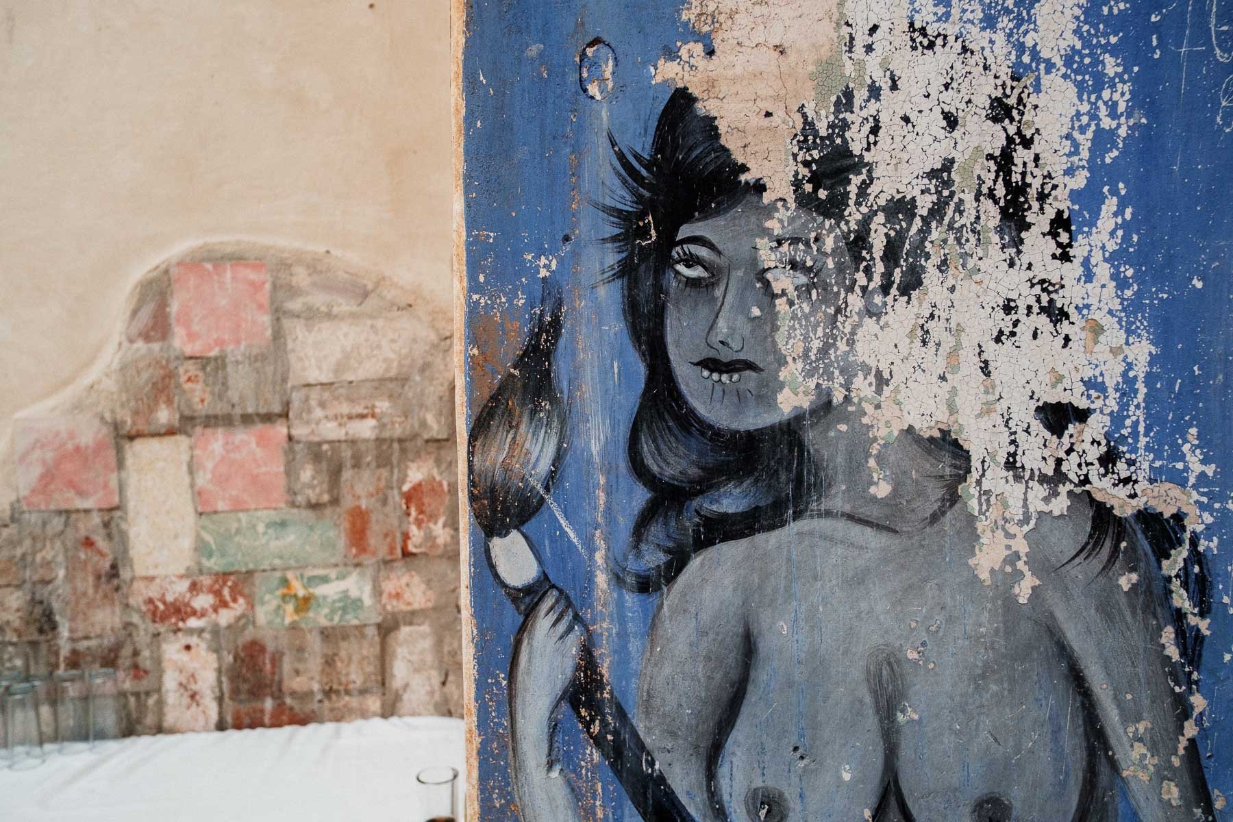 Ancient, weathered wall paintings and frescoes visible within the historic structure of Proyecto Murguia wedding venue.