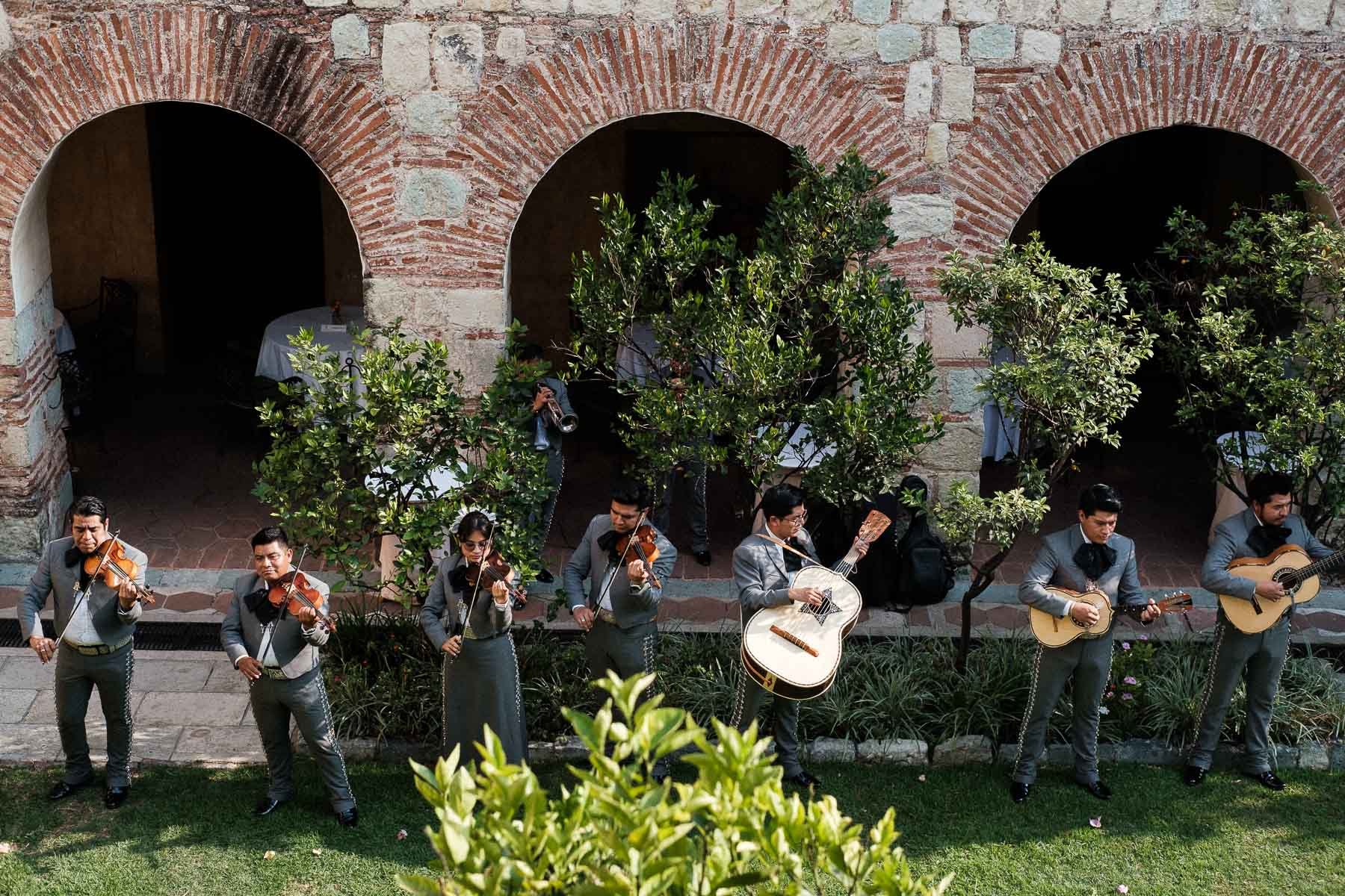 Traditional Mexican mariachis playing music during a pre-ceremony cocktail hour in the historic stone courtyard of Quinta Real Oaxaca.
