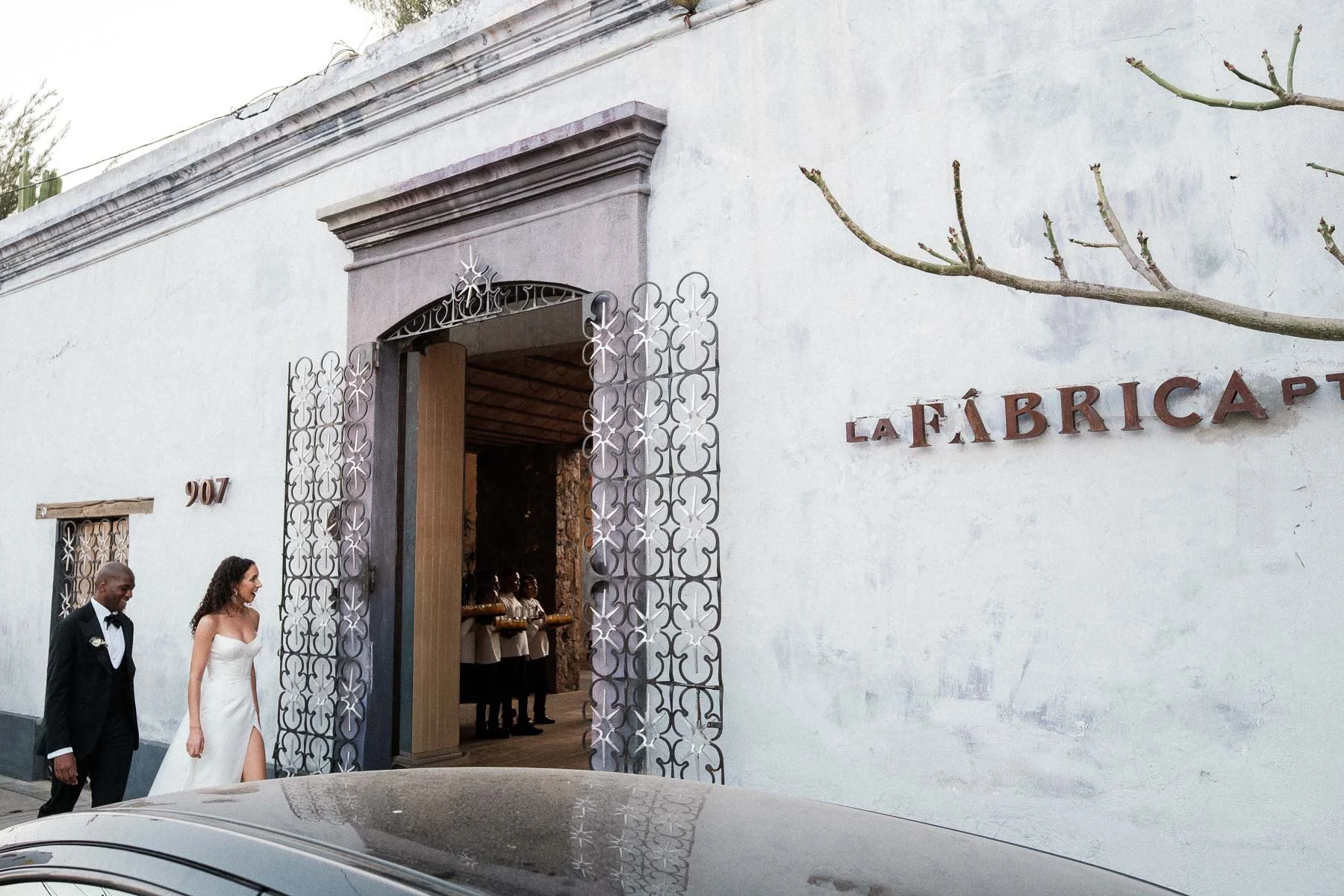 A joyful couple arrives at the entrance of La Fabrica Patio on Macedonio Alcala street, excited to see their wedding reception setup for the first time.