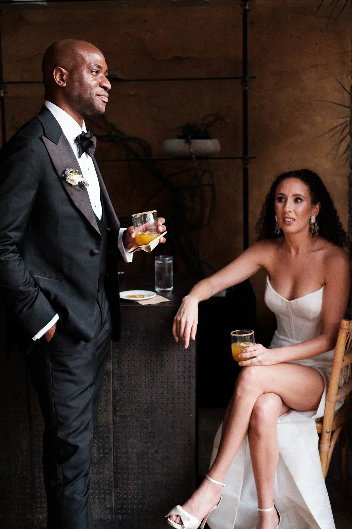 Candid moment of the bride and groom sharing a quiet cocktail before their grand entrance at La Fabrica Patio.