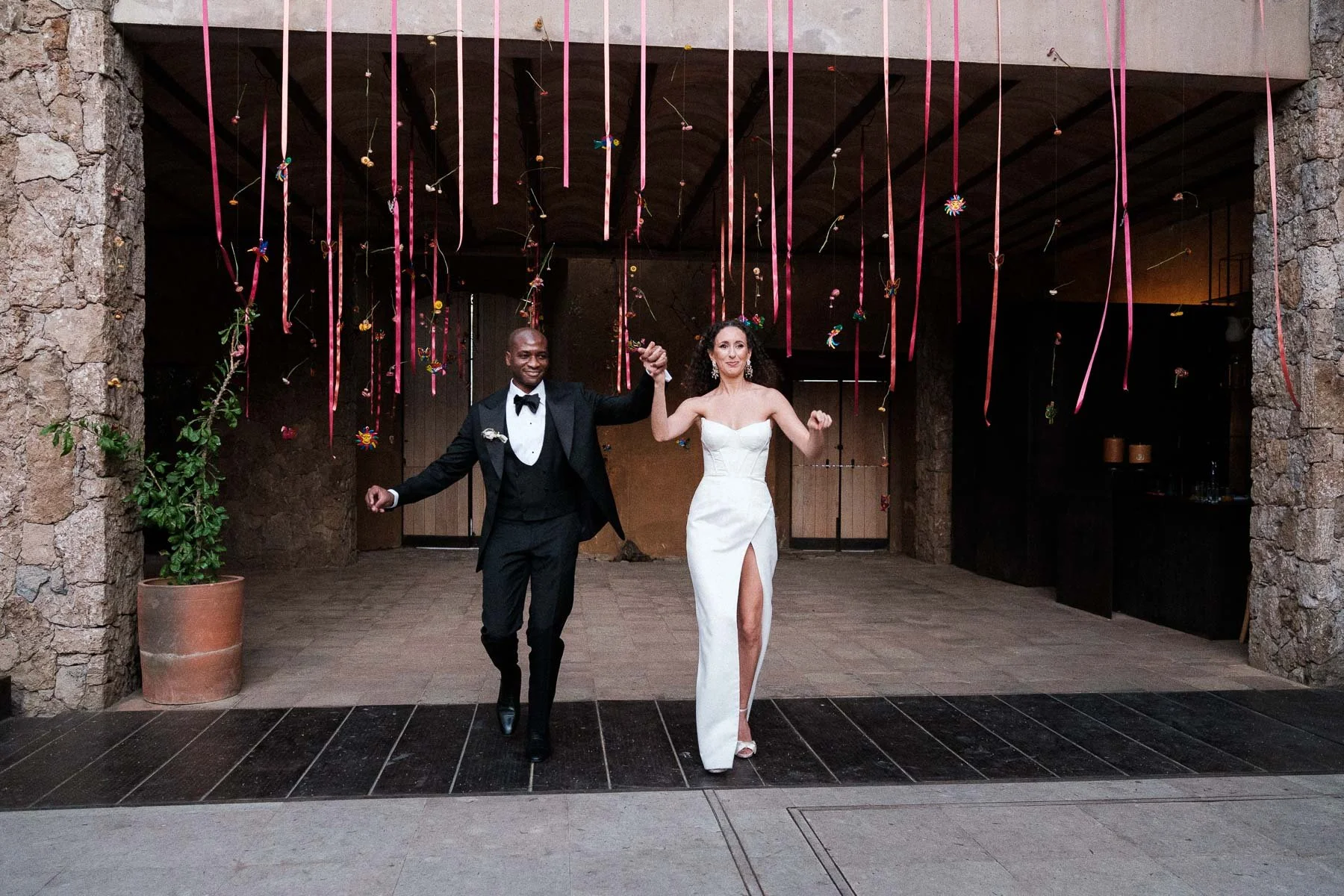 High-energy grand entrance of the couple into their wedding reception at La Fabrica Patio, surrounded by family and friends.