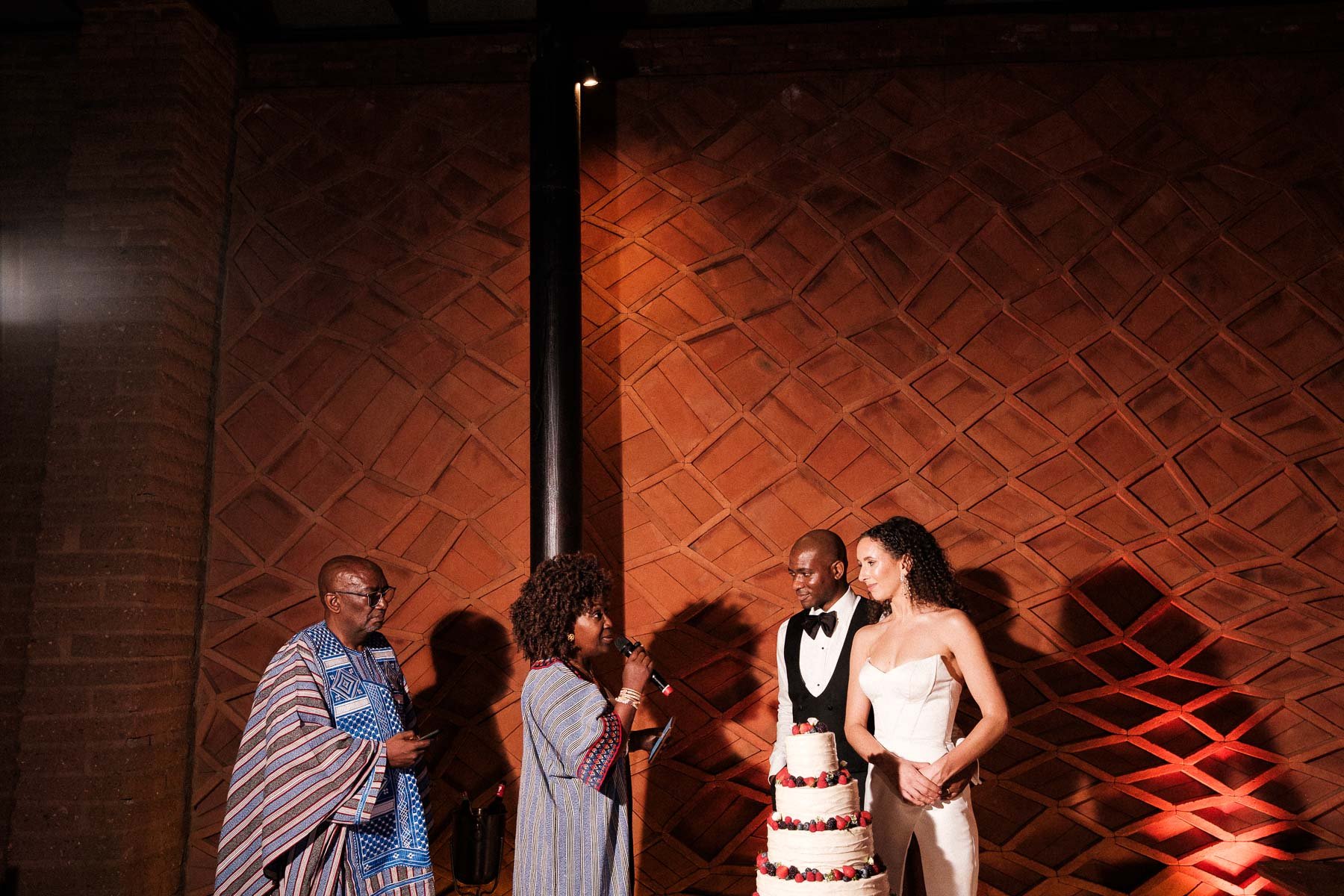 A wedding guest lights a cigar during the reception, capturing the relaxed and celebratory mood at La Fabrica Patio.