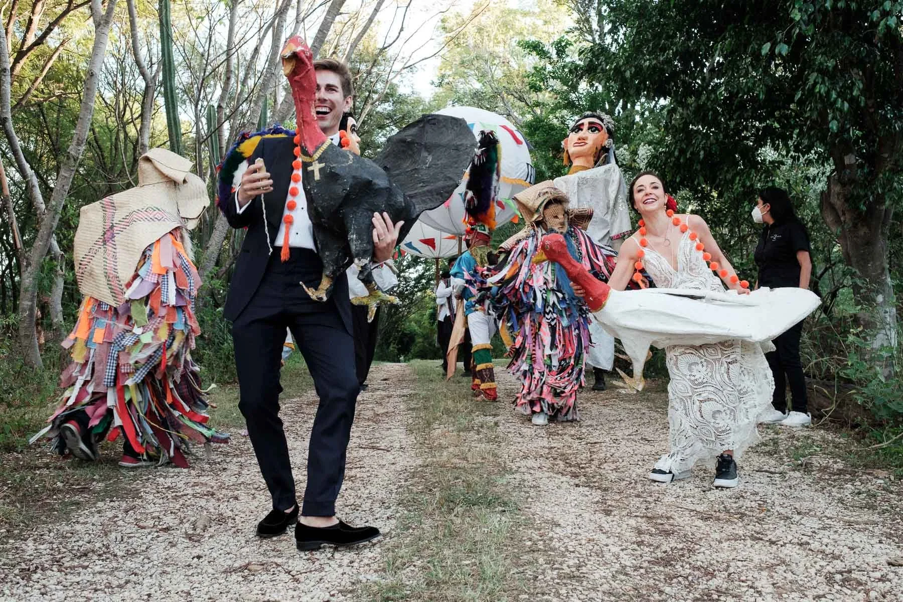 The couple dancing during a traditional Oaxacan calenda at Casa Dos Lagos, featuring unique large decorative ajolotes (axolotls).