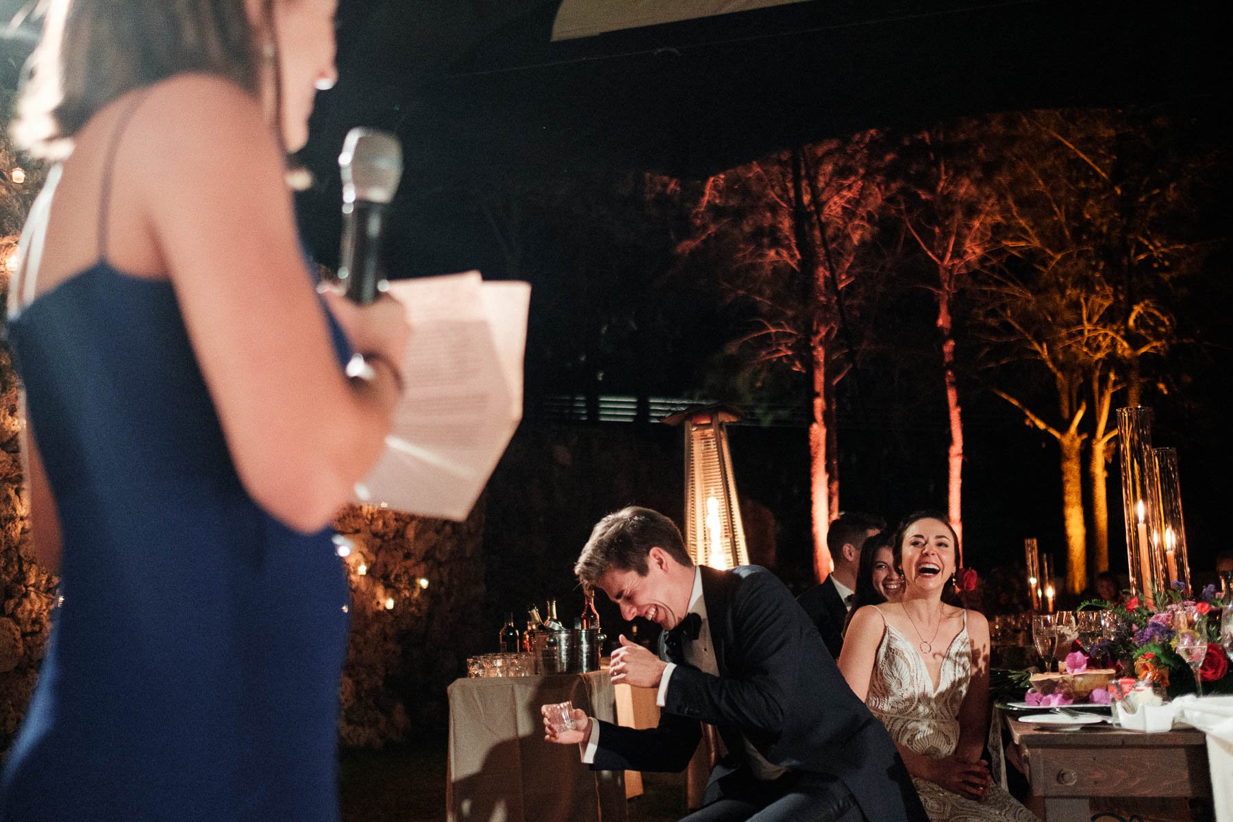 Groom laughing during funny and heartfelt speeches at the wedding reception dinner in Casa Dos Lagos.