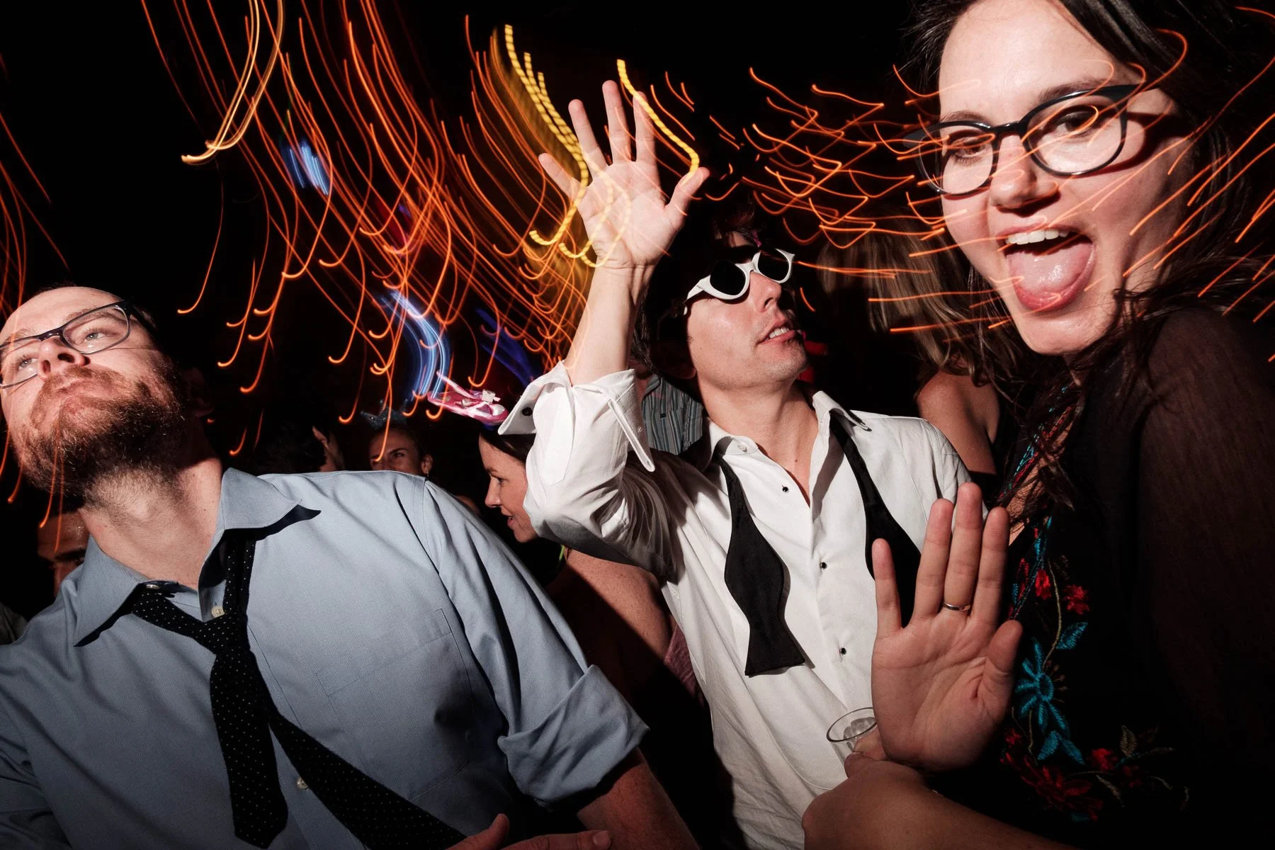 High-energy wedding party at Casa Dos Lagos with vibrant lights and guests dancing, capturing the final celebration of the day.
