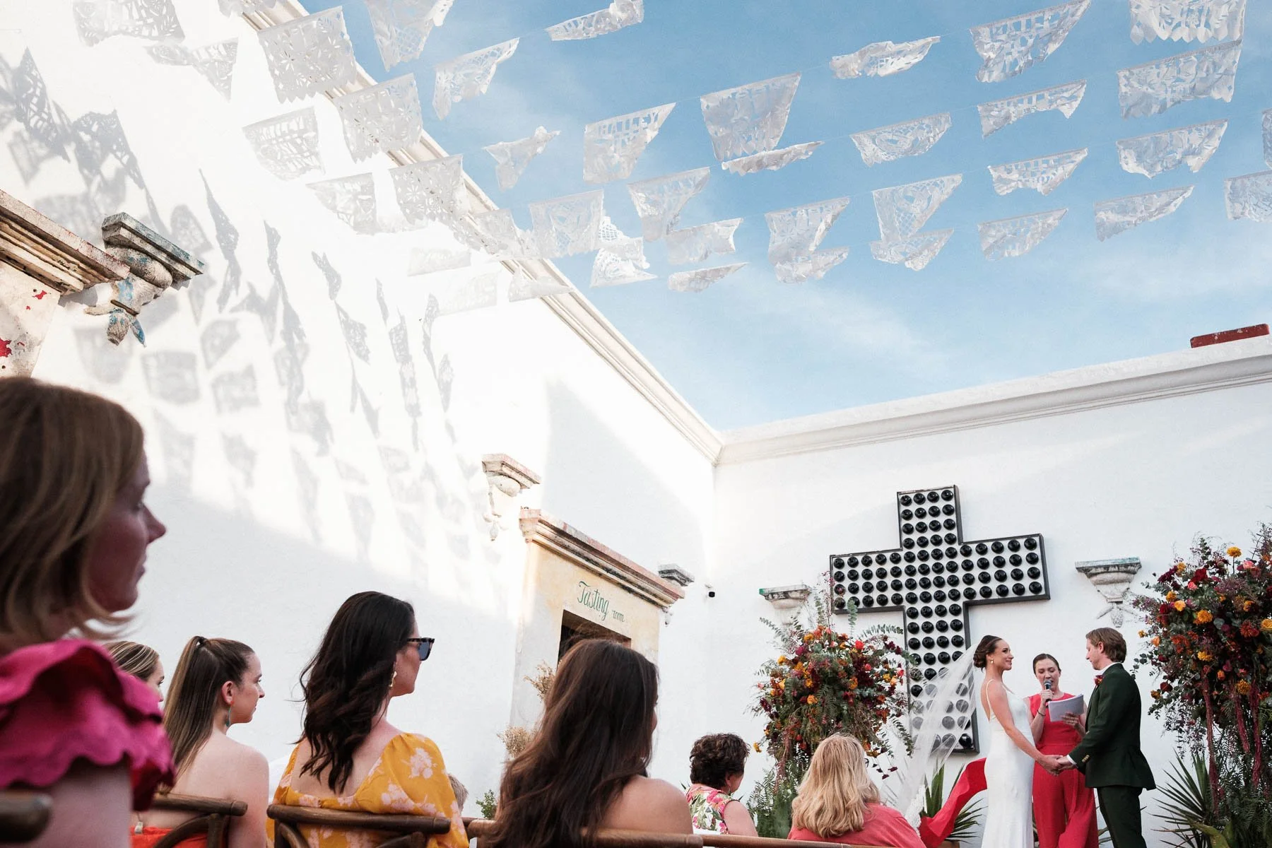 Intimate wedding ceremony at Casa Convite Oaxaca featuring traditional white papel picado decorations, blending heritage with modern boutique style.
