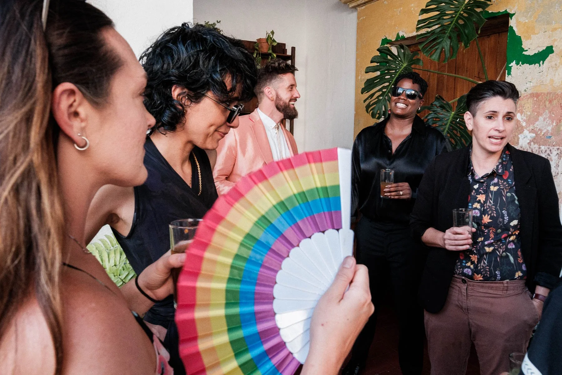 A group of LGBTQ+ friends laughing and sharing a joyful moment during the cocktail hour at Casa Convite, highlighting the inclusive and celebratory environment of destination weddings in Oaxaca.
