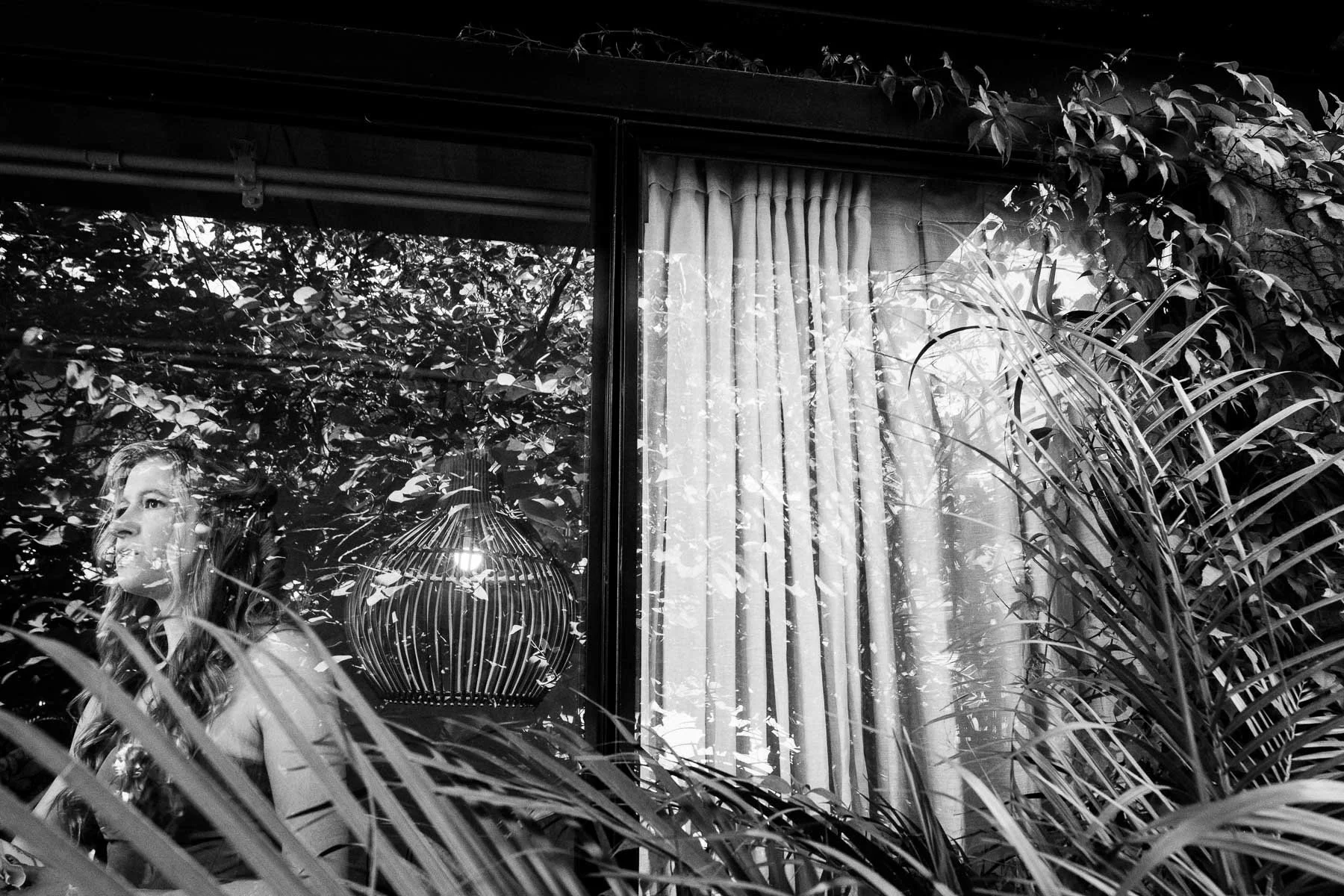 The bride framed in a window reflecting the inner courtyard of a historic Oaxaca home.