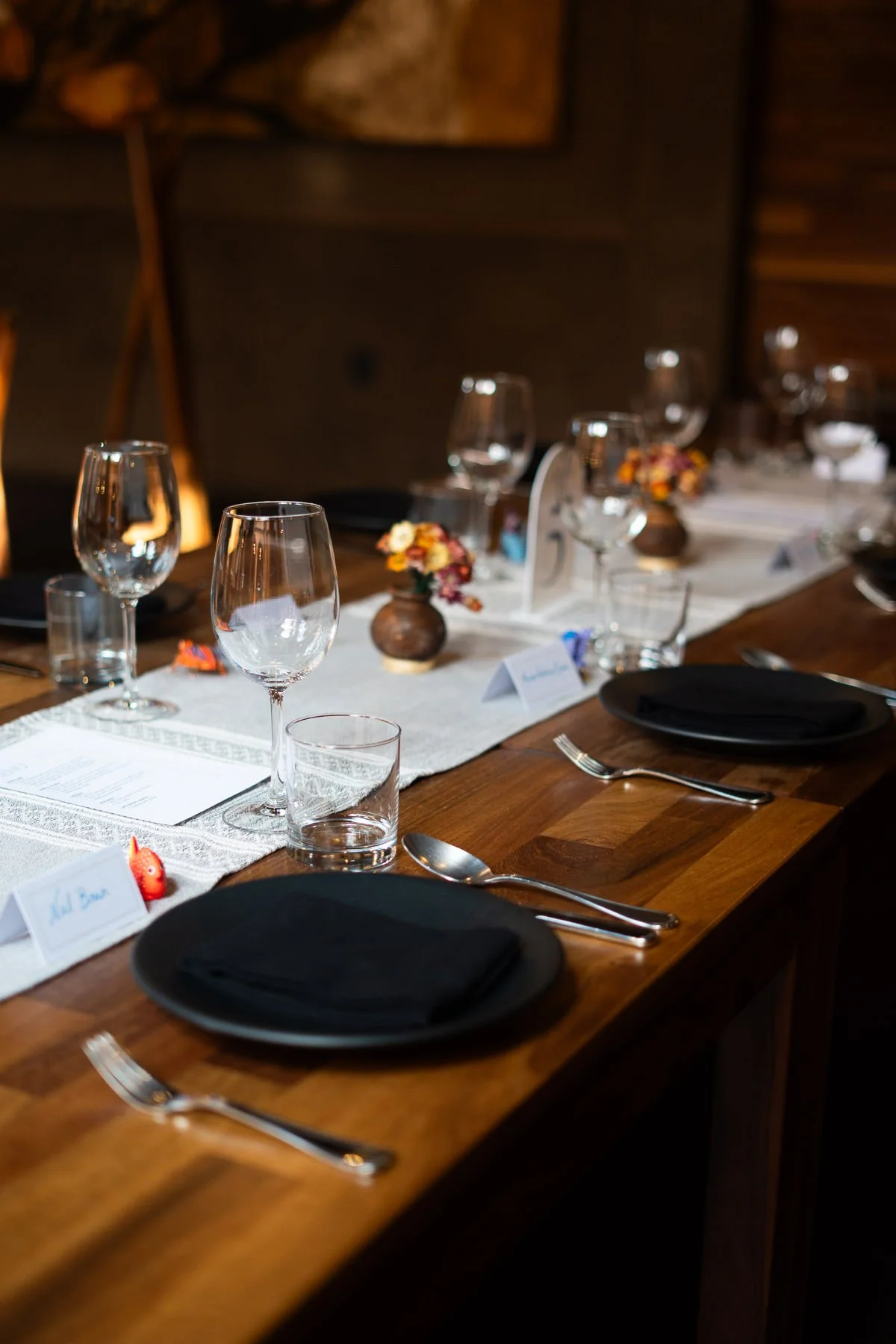 A beautifully set wedding table at Asador Bacanora featuring traditional alebrijes and floral arrangements.
