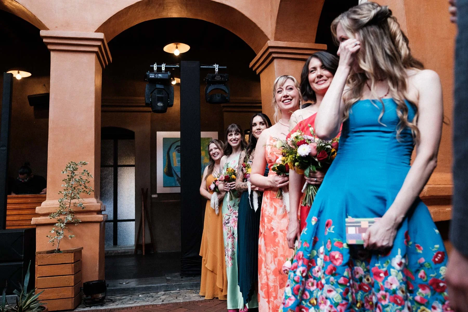 An emotional moment of the bride crying while looking at her bridal party during the ceremony.