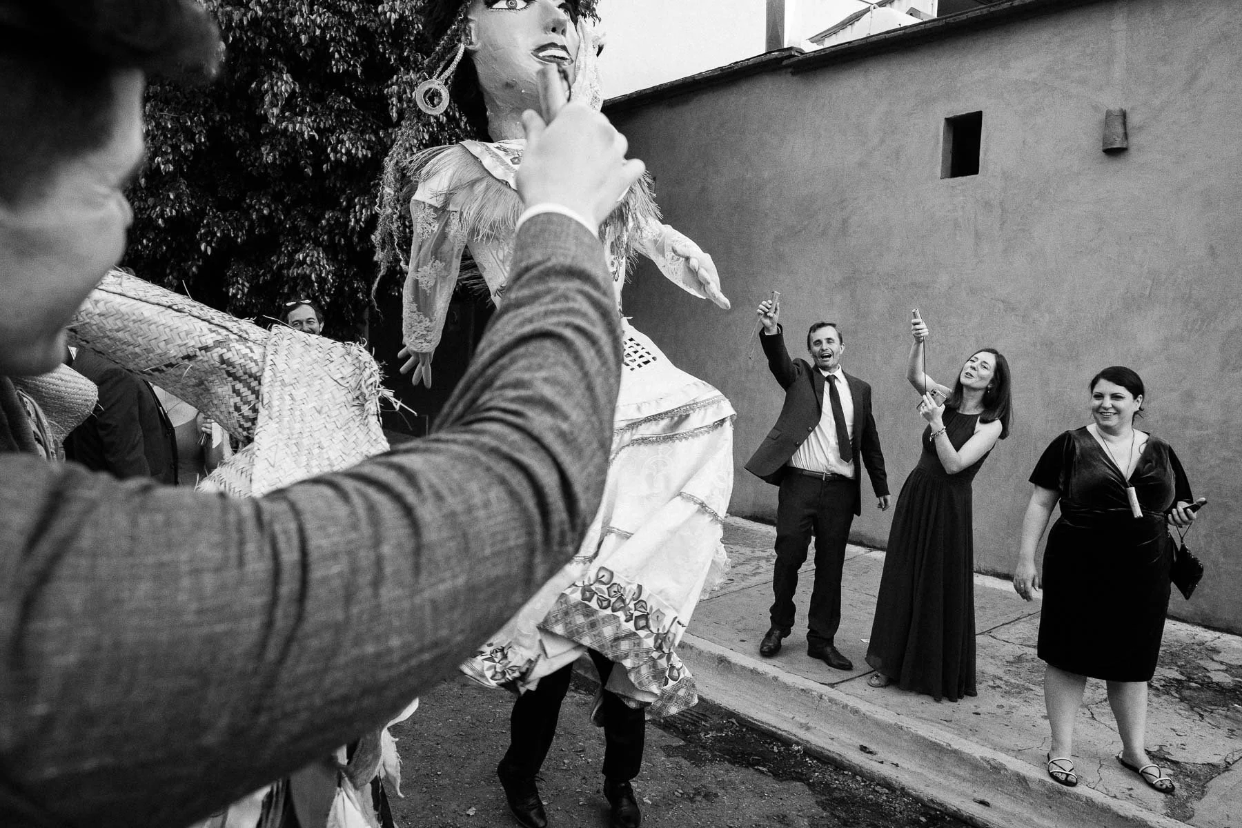 Guests making a mezcal toast to the couple dancing in the middle of a cobblestone street in Jalatlaco.