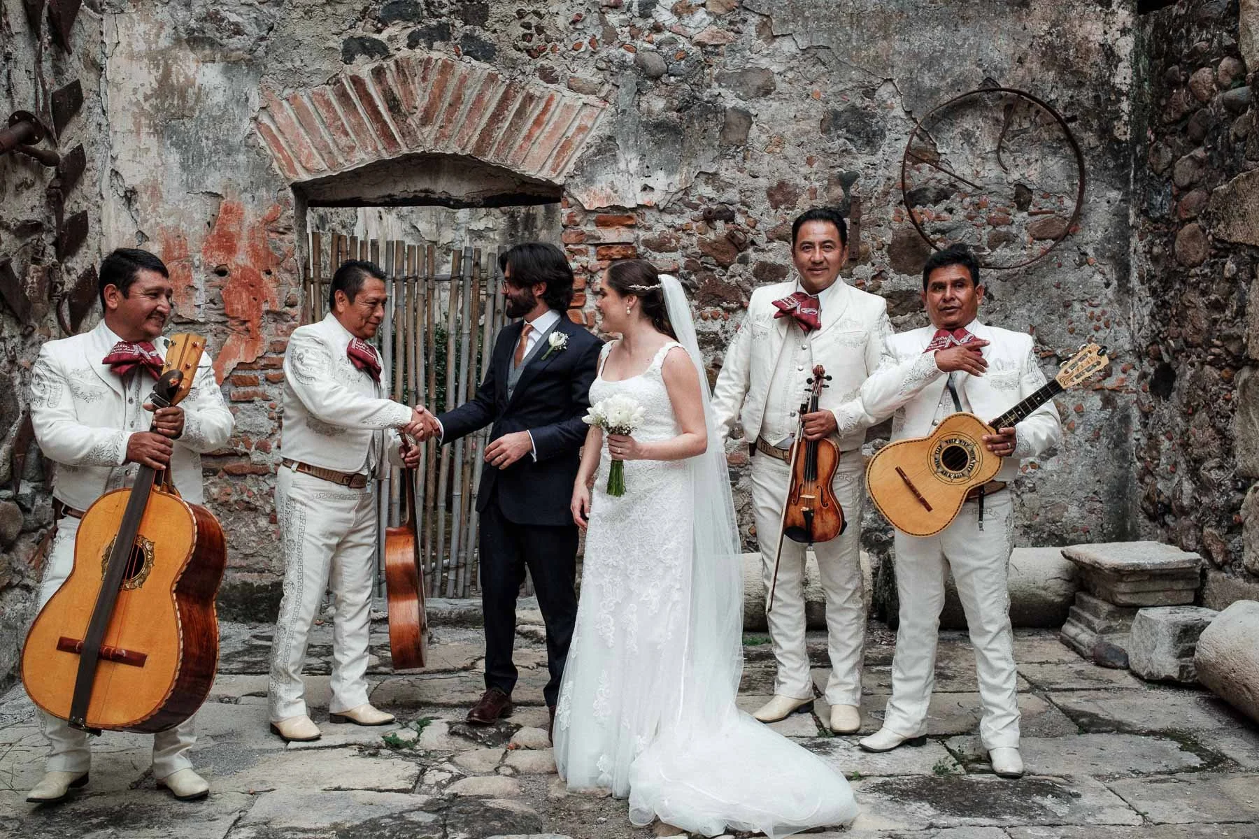 Newlyweds sharing a laugh with the mariachis right after the formal photos.