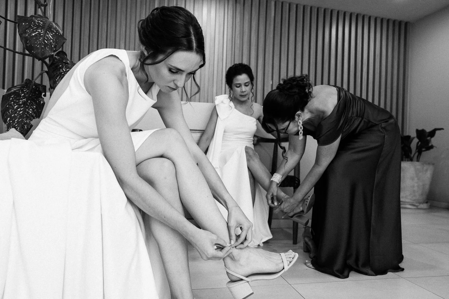 Brides sharing a quiet moment in their wedding dresses before the ceremony.