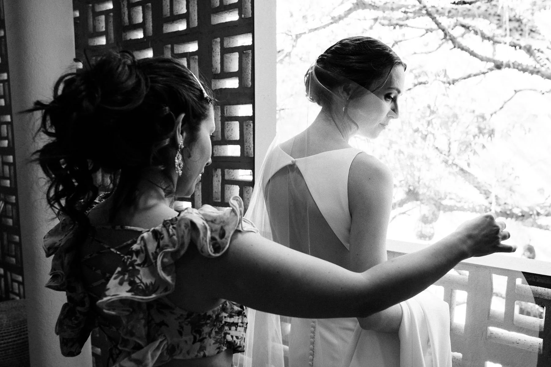 Documentary shot of a bride putting on her veil during wedding prep.