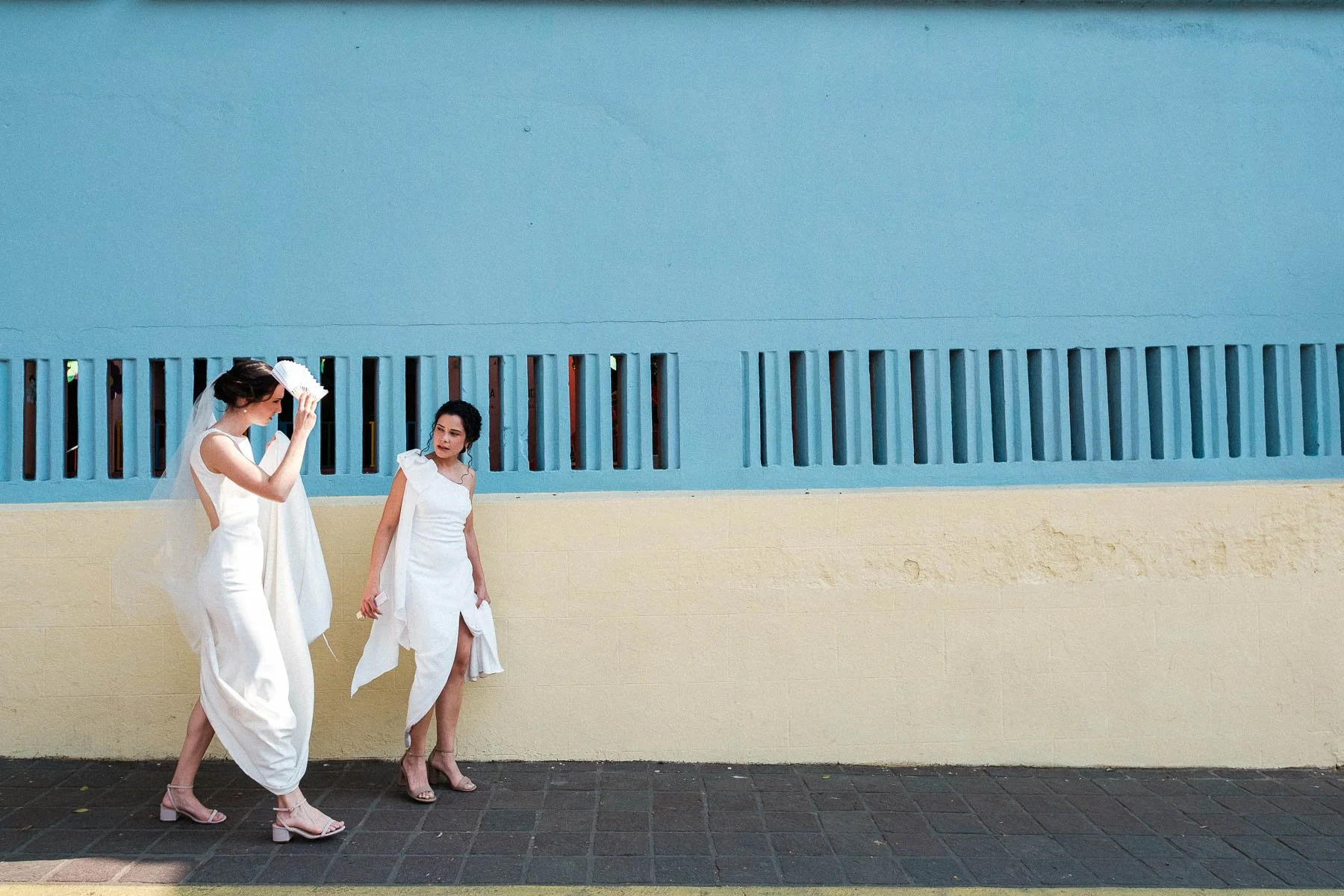 Brides walking past the colorful, textured walls of Jalatlaco, Oaxaca.