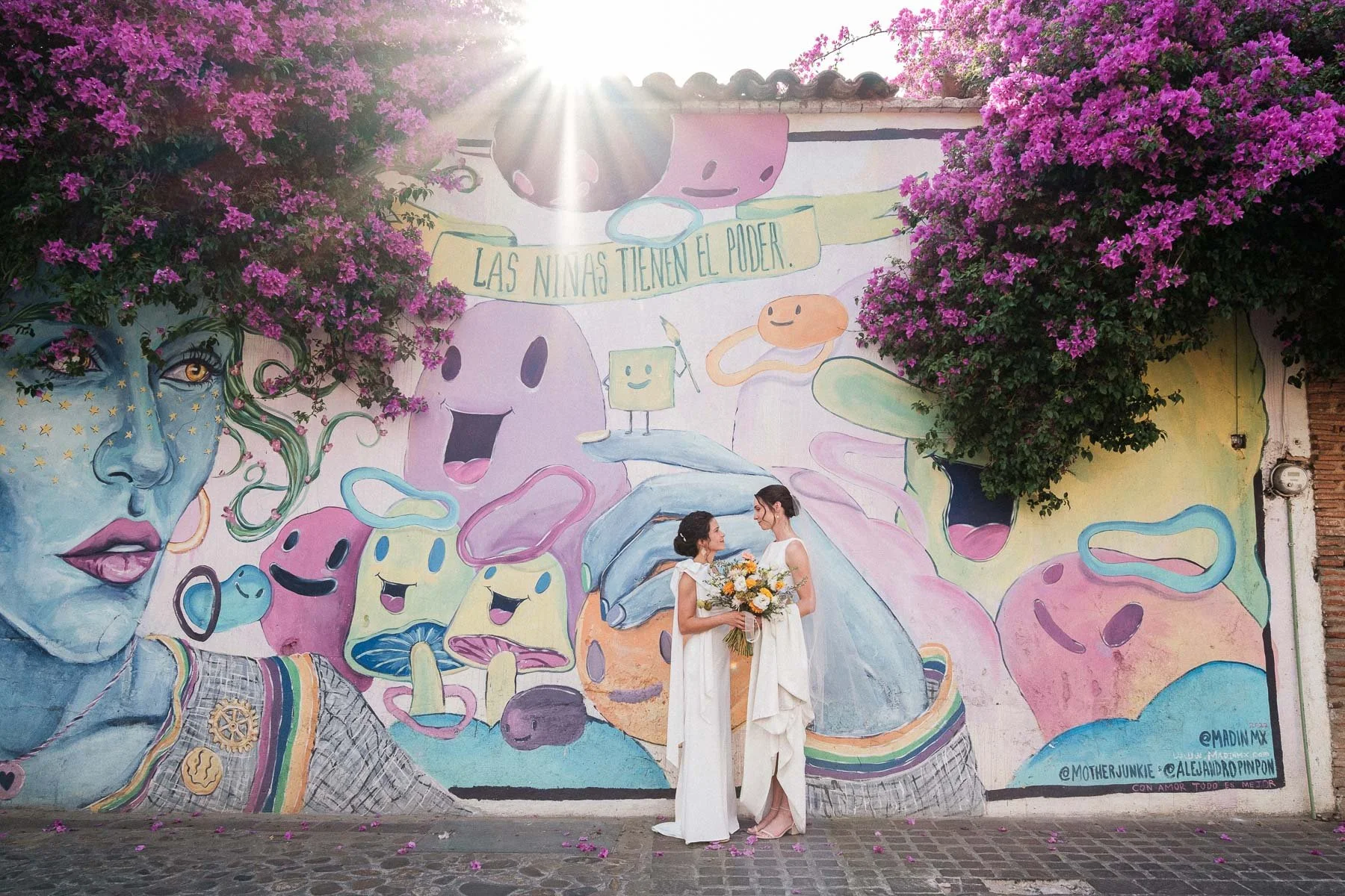 Brides portrait by a Jalatlaco mural saying girls have the power by Lucca Lazzarini.