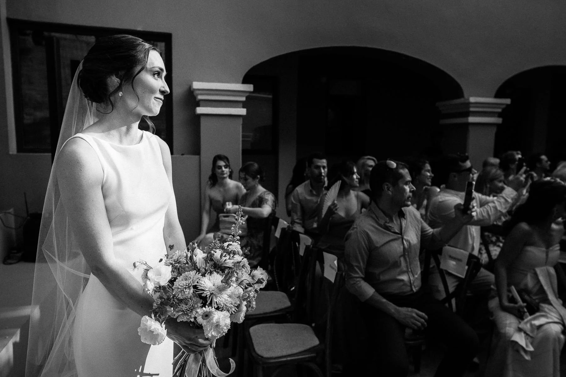 Bride looking at her partner with emotion during the ceremony by Lucca Lazzarini.