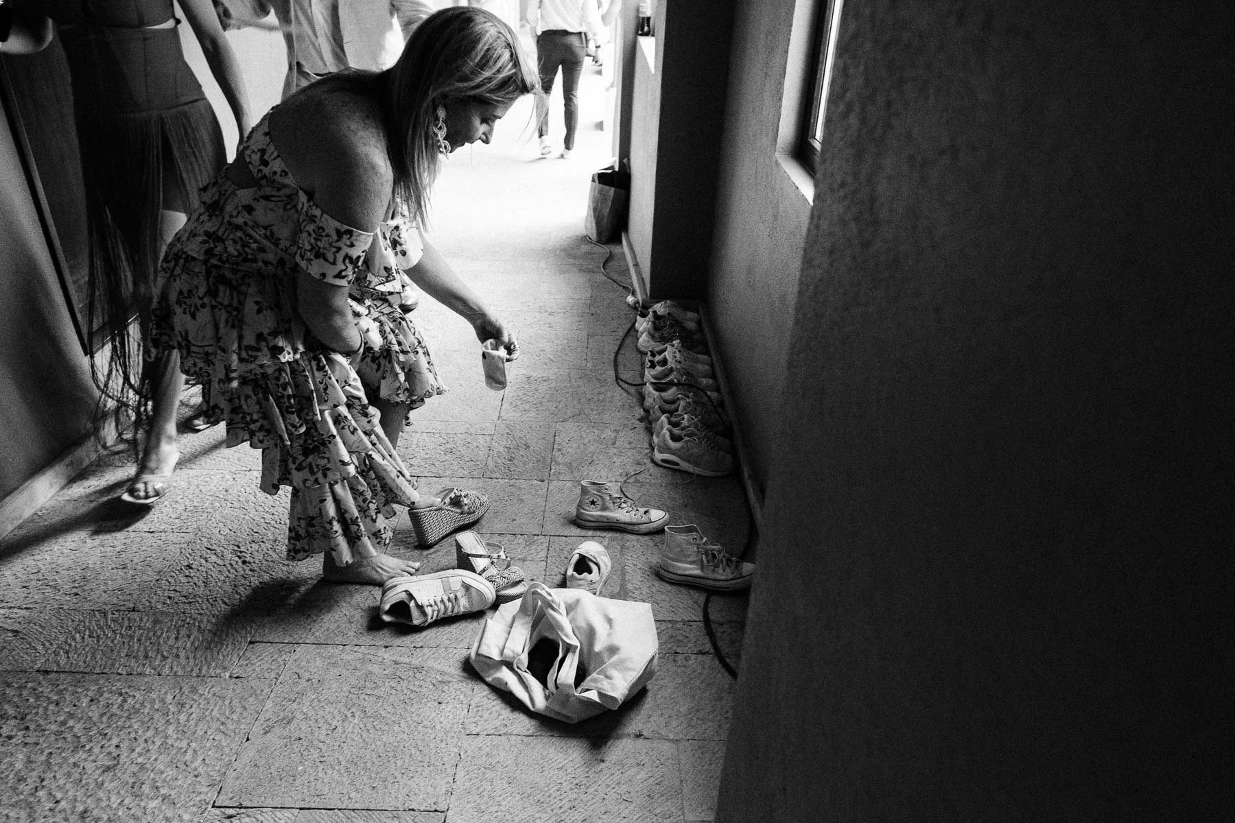 A wedding guest switching to comfortable shoes before the Calenda parade.
