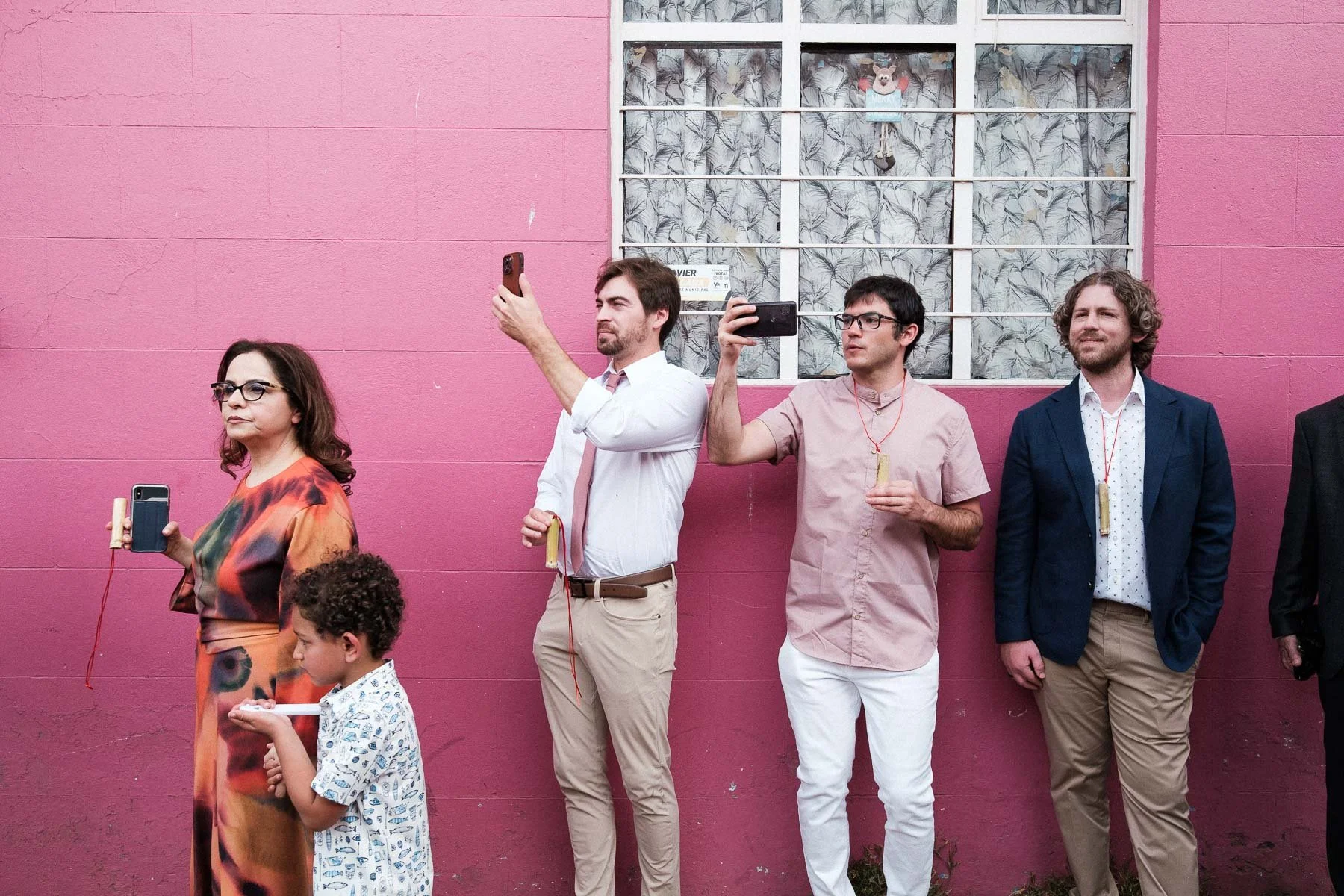 Wedding guests capturing the Oaxacan Calenda parade on their phones.