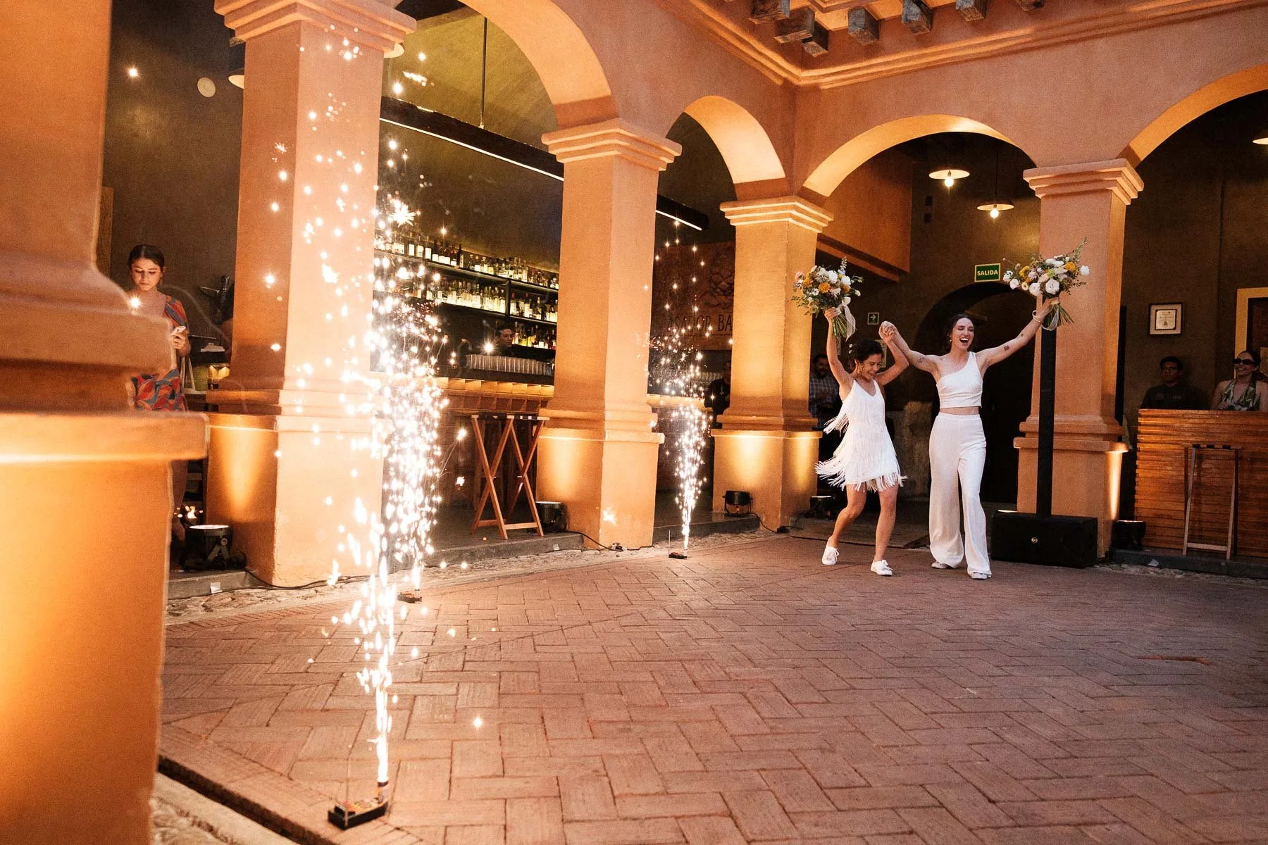 The brides entering their reception at Asador Bacanora with pyrotechnics.