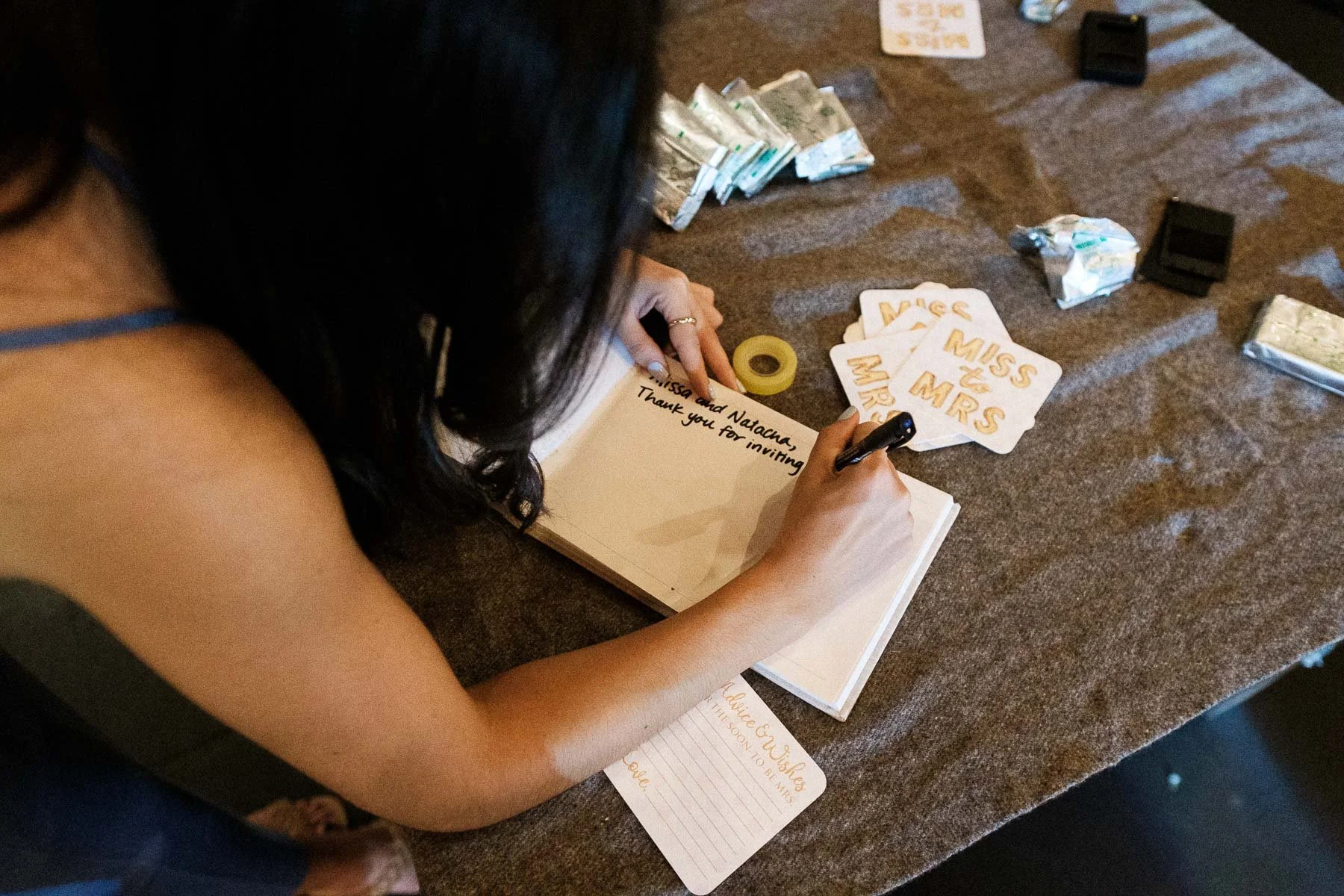 A guest signing the wedding guestbook with personal notes.