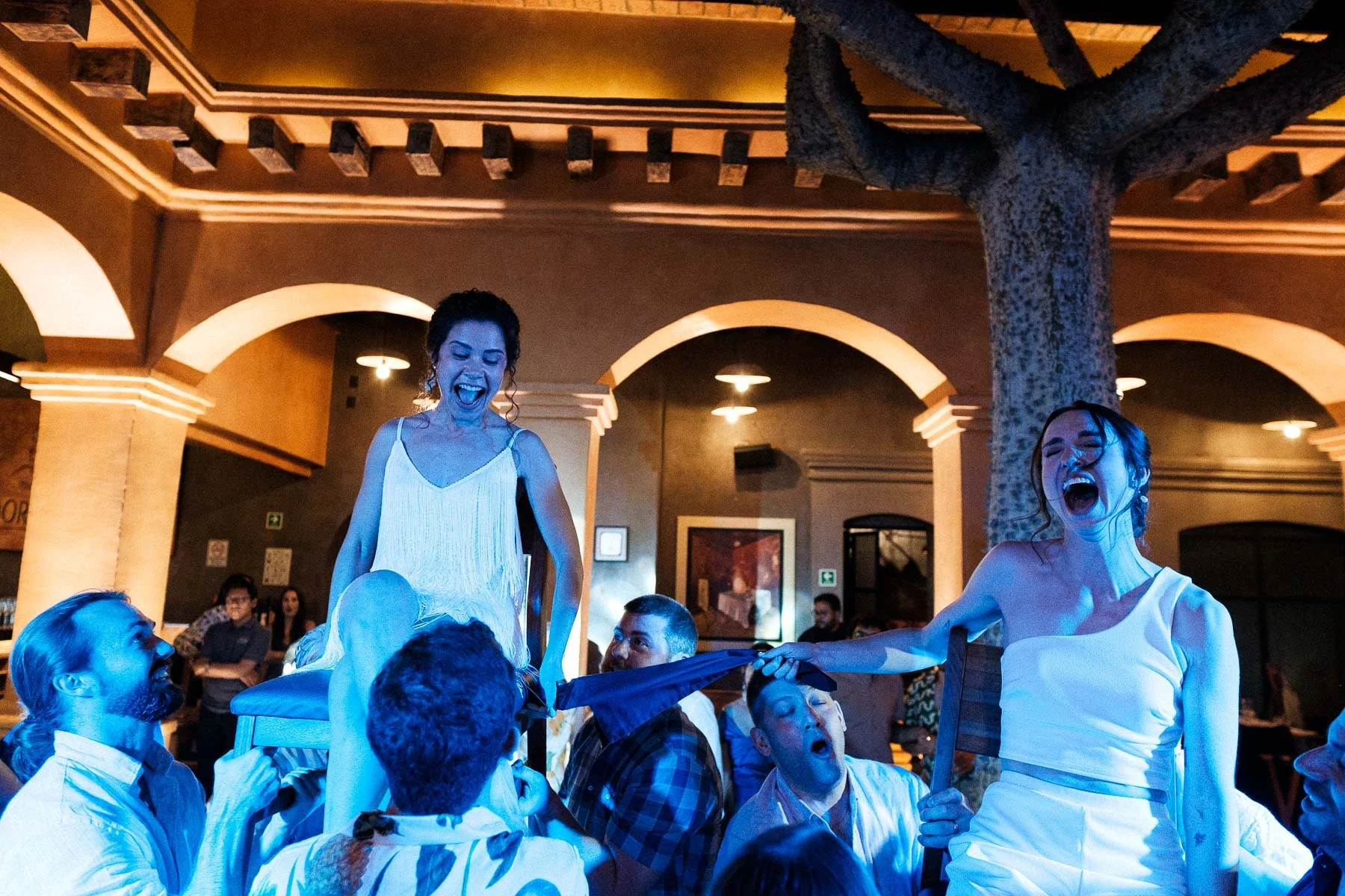The brides being lifted in chairs during a traditional Jewish celebration.
