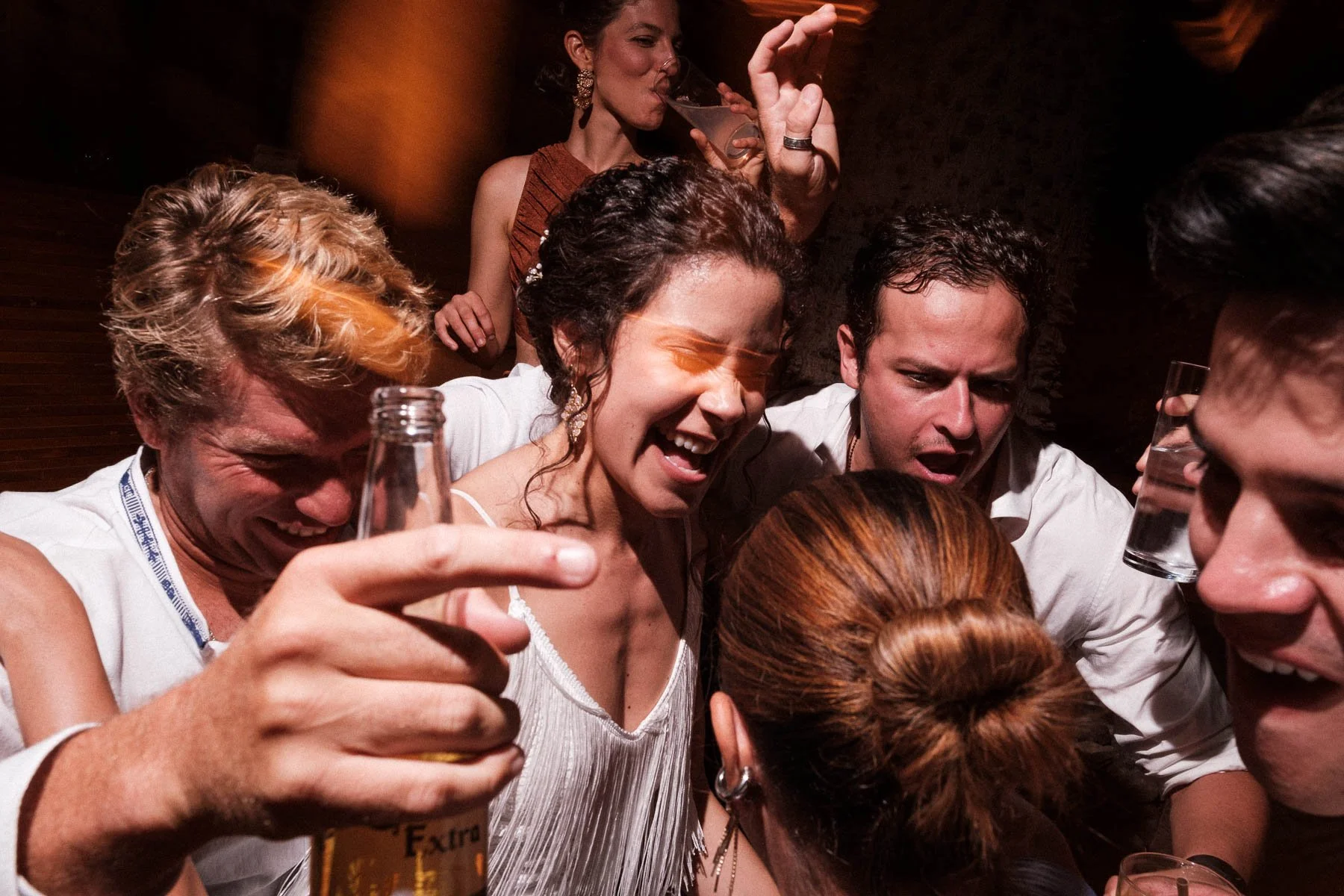 The brides and friends sharing a heartfelt hug on the dance floor.