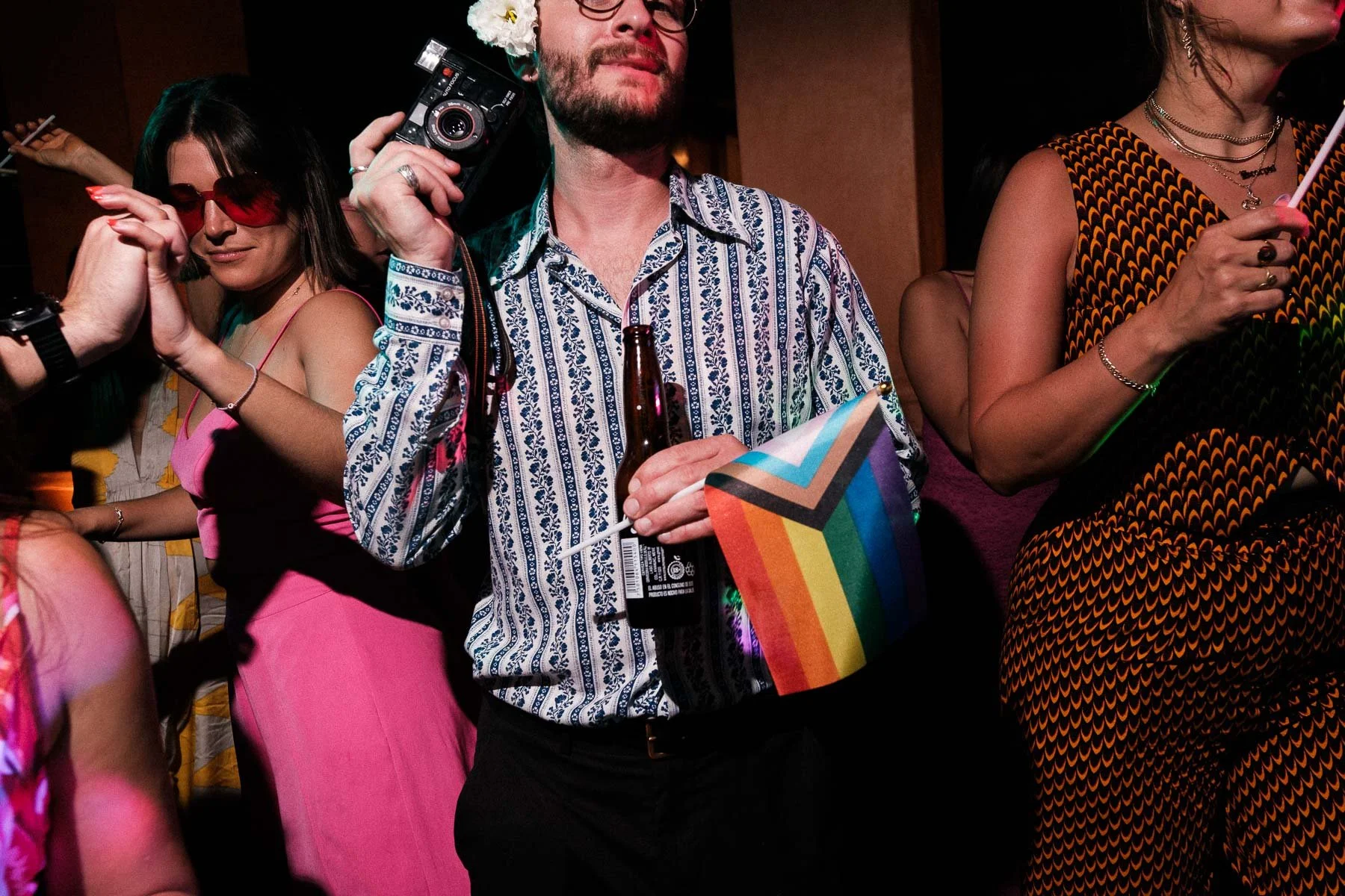 A guest capturing the night while holding an LGBTQ pride flag.