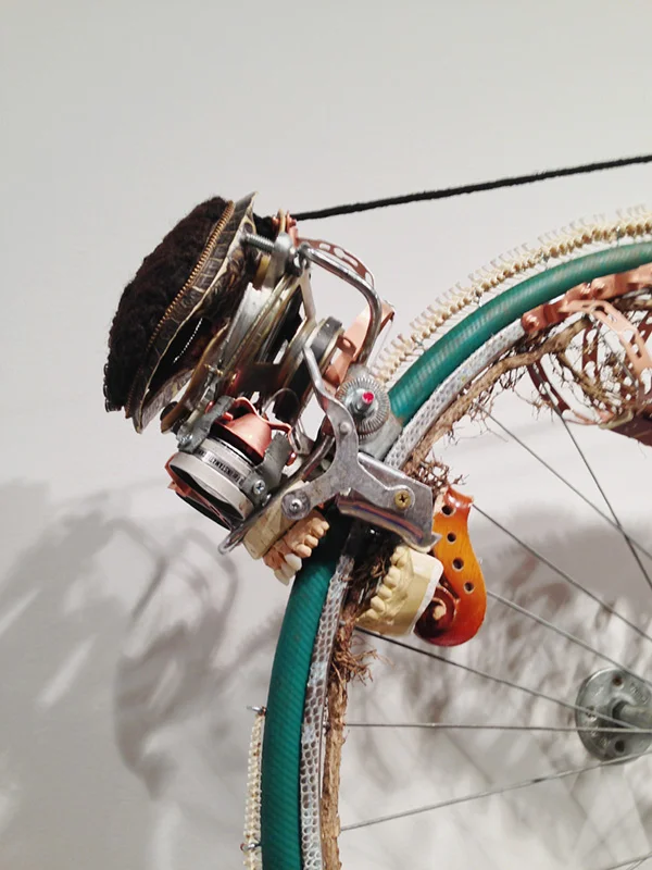 5 Lorna Williams-Ouroboros-2013-hair, plumbing hardware, violin parts, photography lenses, snake vertebrae, bike wheel, hose, ukulele neck, bike chain, plaster teeth, bike seat, speaker, snake shedding, root, rope, cement-88x60x13-detail.jpg