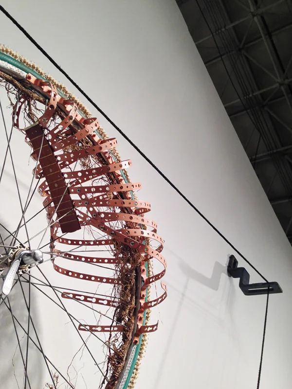6 Lorna Williams-Ouroboros-2013-hair, plumbing hardware, violin parts, photography lenses, snake vertebrae, bike wheel, hose, ukulele neck, bike chain, plaster teeth, bike seat, speaker, snake shedding, root, rope, cement-88x60x13-detail.jpg