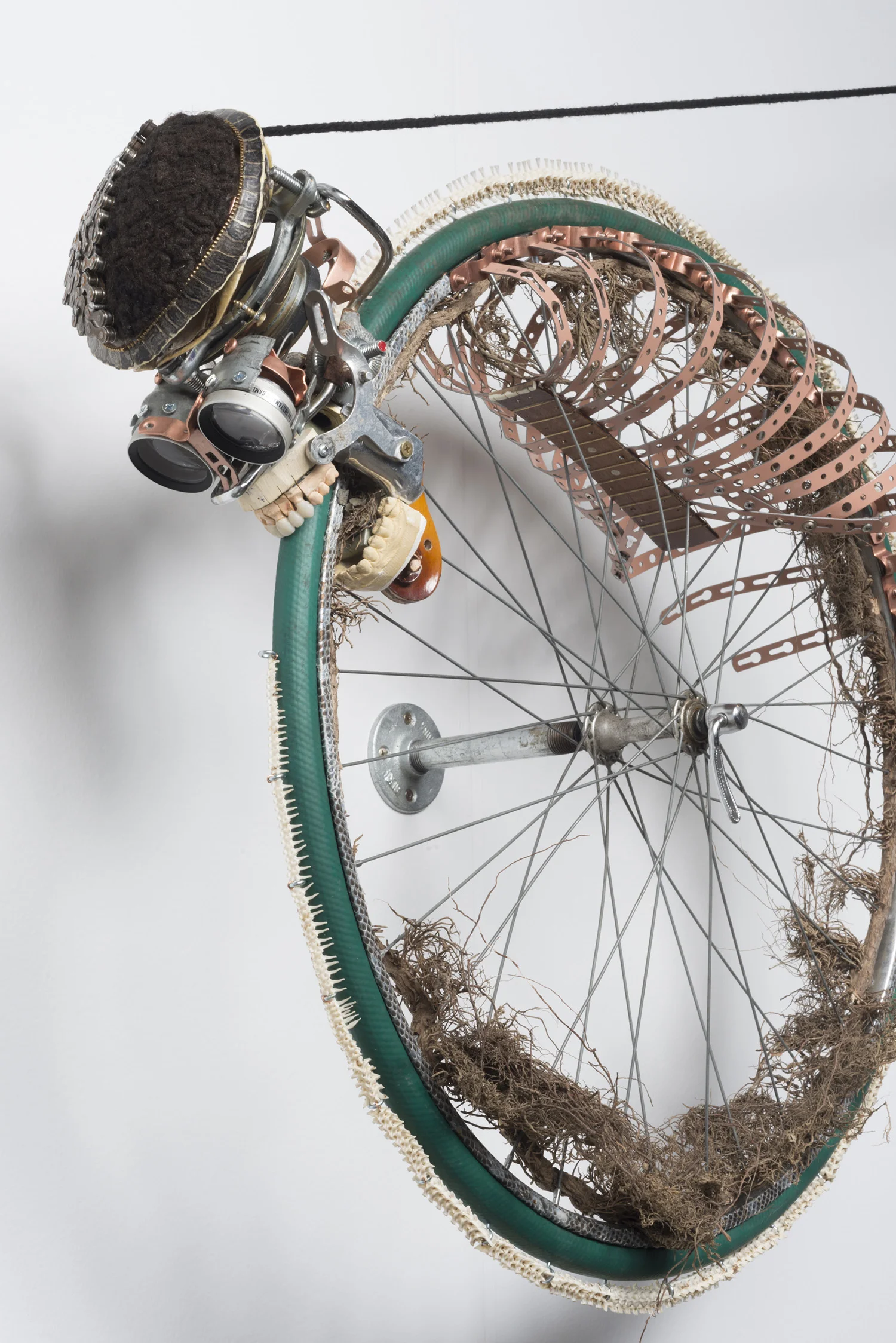 Lorna Williams-Ouroboros-2013-hair, plumbing hardware, violin parts, photography lenses, snake vertebrae, bike wheel, hose, ukulele neck, bike chain, plaster teeth, bike seat, speaker, snake shedding, root, rope, cement-88x60x13-detail-1.jpg