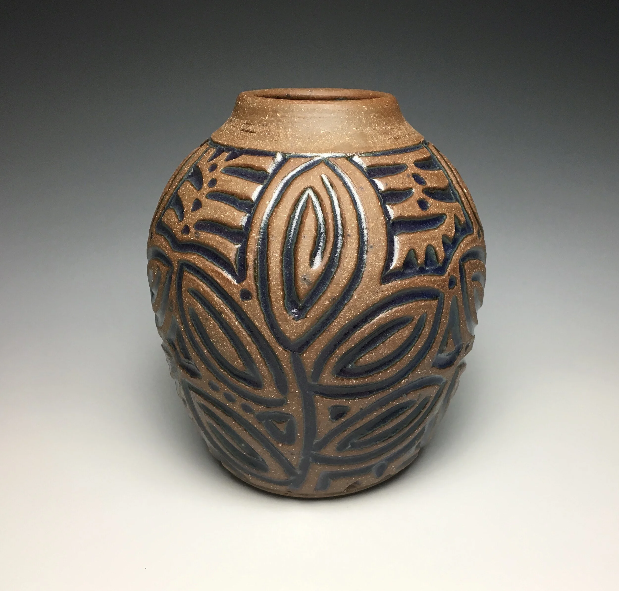 Carved vase. 2019. Approx. 6 inches tall by 4.5 inches wide. Transparent dark blue glaze in hand-carved surface design. Stoneware clay body.