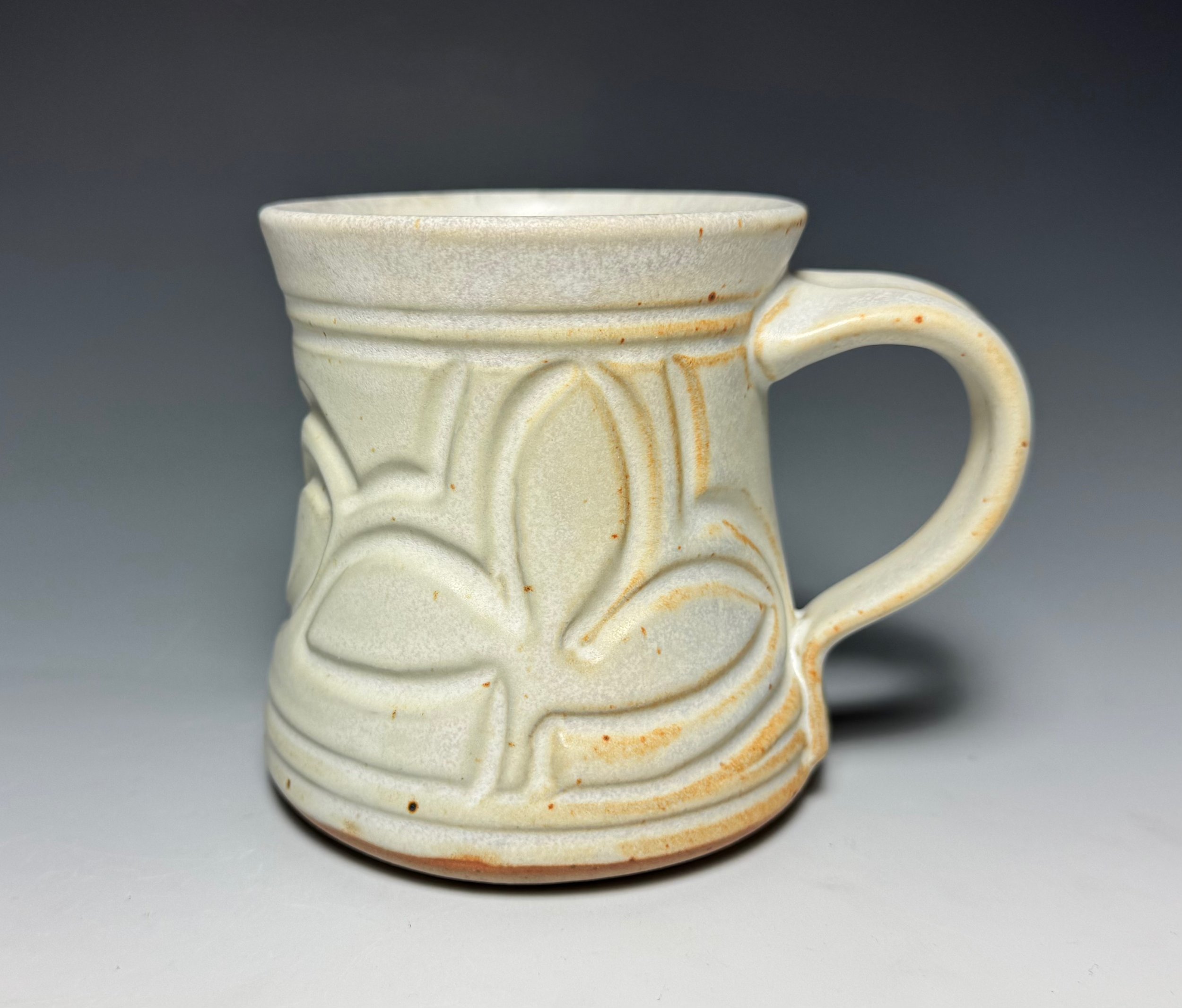 Coffee Mug With Hand-Carved Surface and Matte White Glaze.