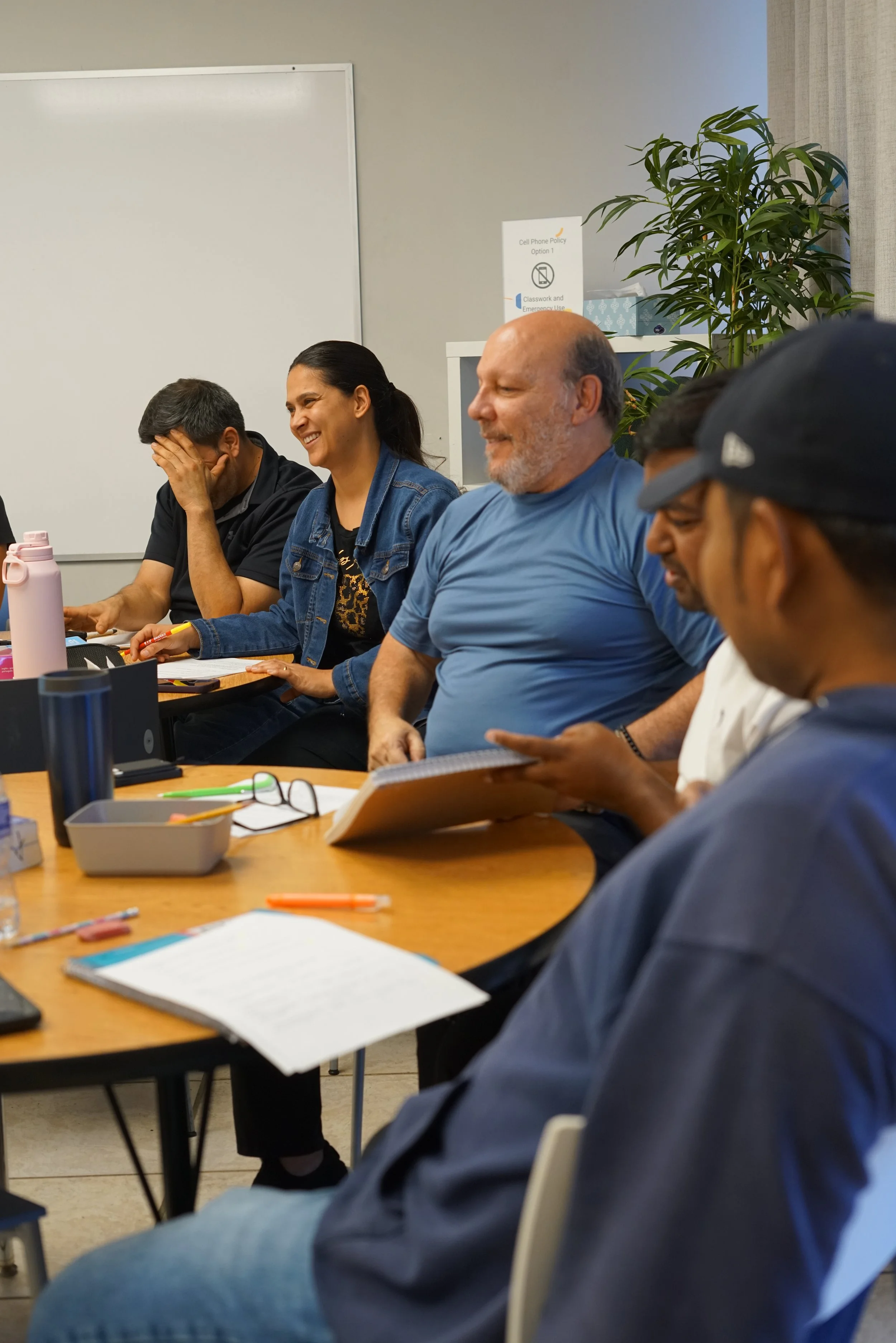 smiling adults enjoy conversational English practice in a comfortable classroom