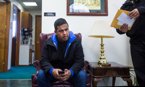 For the fourth time in two months, Edwin Silva waits in the lobby to finalize an I-589 application, withholding of removal, with his immigration lawyer's assistant at the main office in Dearborn. Photo by Andraya Croft