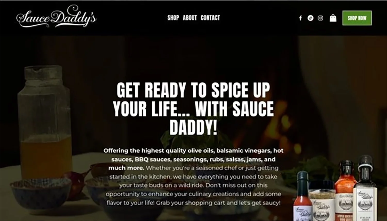 Homepage of Sauce Daddy's website featuring a dark background with a bottle of hot sauce, bowls of seasonings, and sauces in the foreground. Text promotes their high-quality cooking ingredients and encourages shopping.