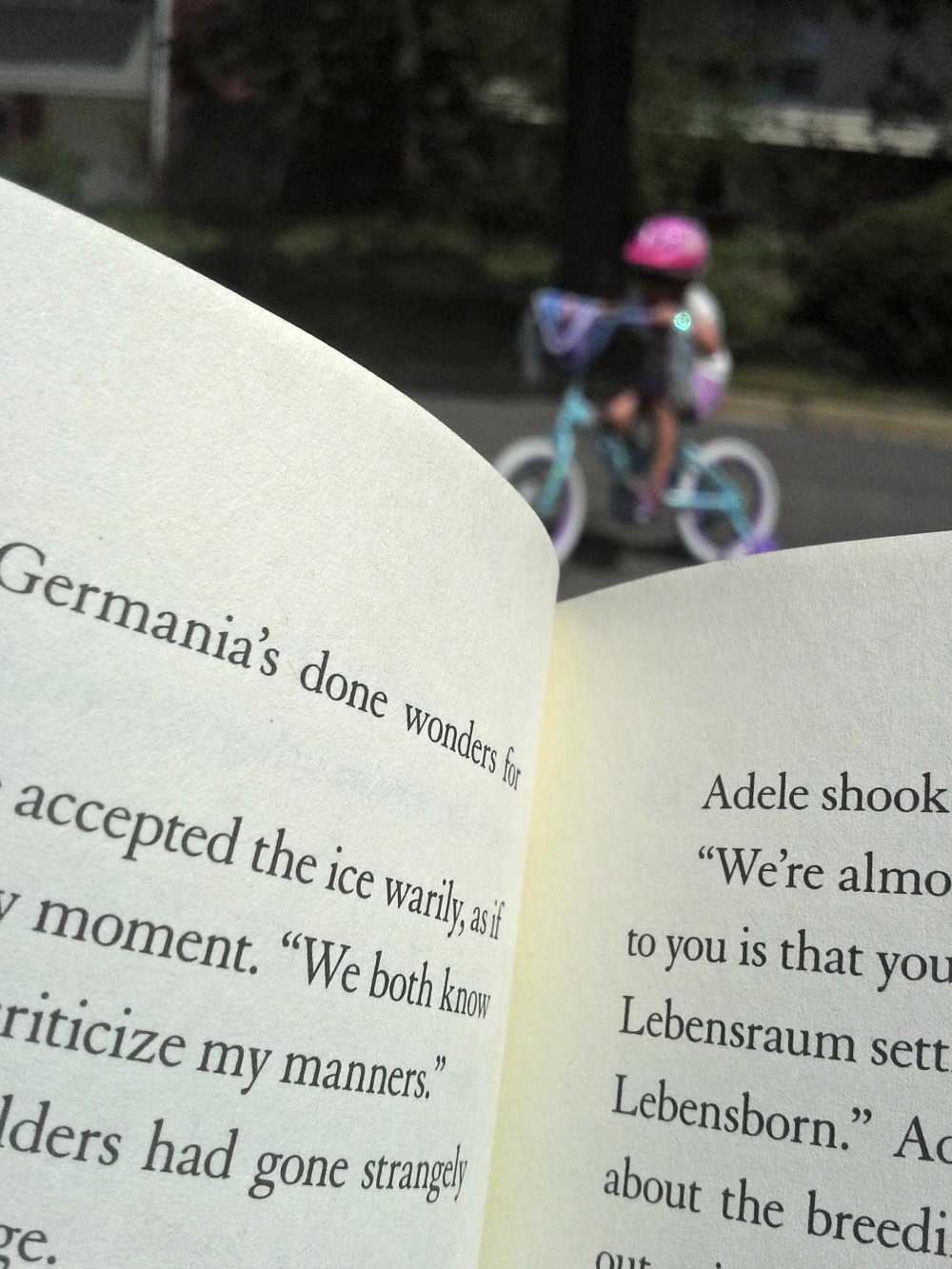 New bikes for the kids have given me a good excuse to sit on the curb while reading a book. (Pictured here: wolf by wolf by Ryan Graudin)